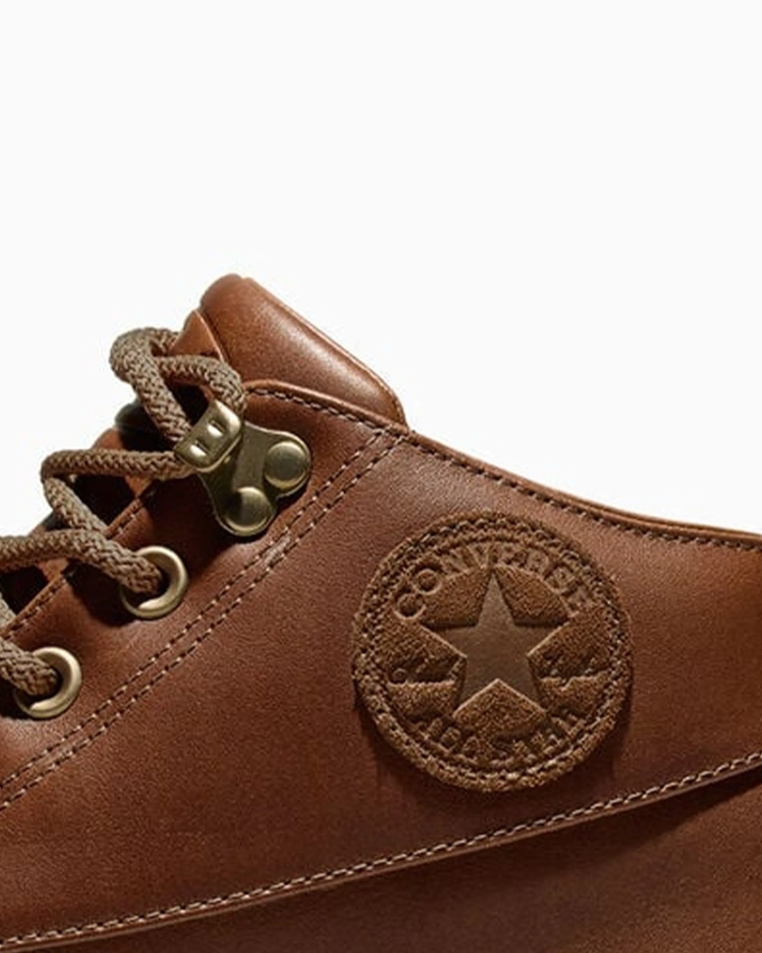 Brown leather Converse All Star sneaker with matching brown laces and metal eyelets.