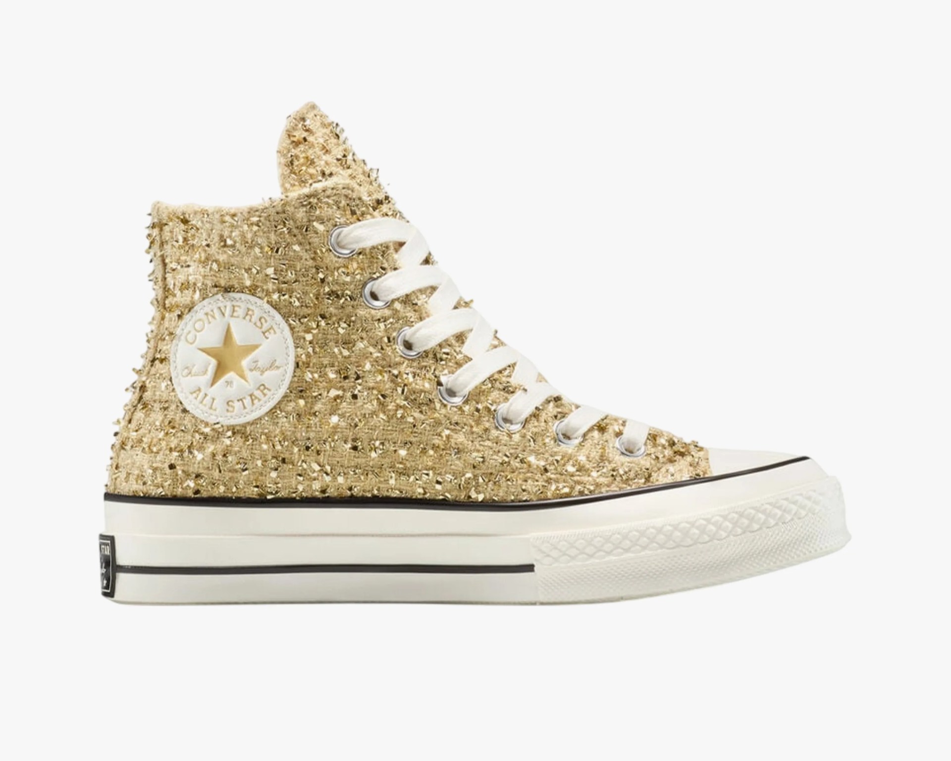 High-top Converse All Star sneaker with gold textured fabric and white rubber sole.