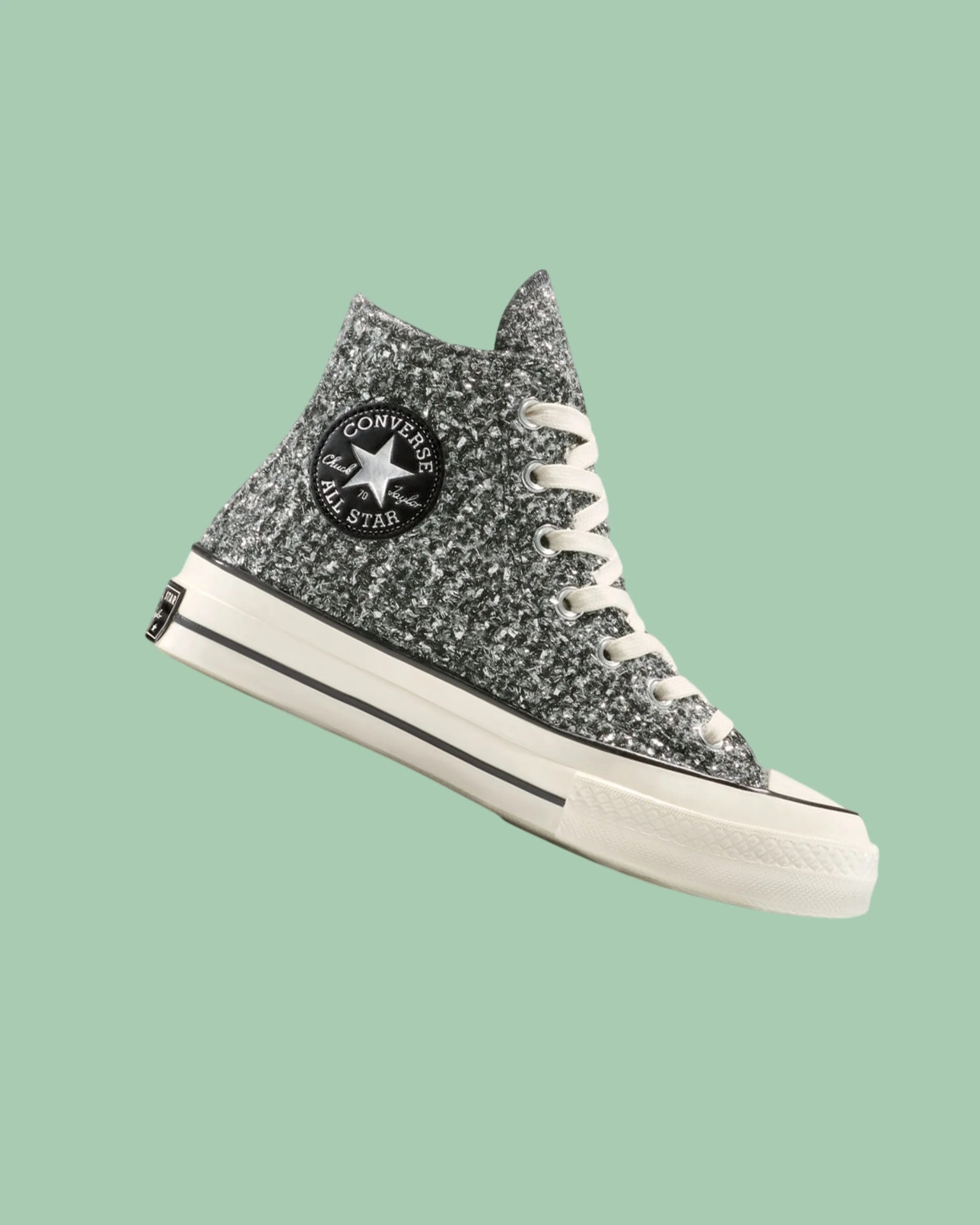 High-top Converse All Star sneaker with textured black and white knit upper and white rubber sole.
