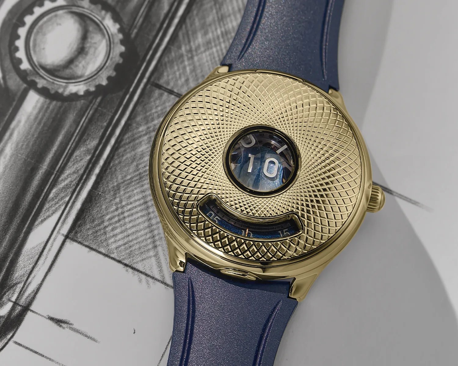Gold watch with a textured dial, digital hour display, and blue rubber strap on a sketch background.