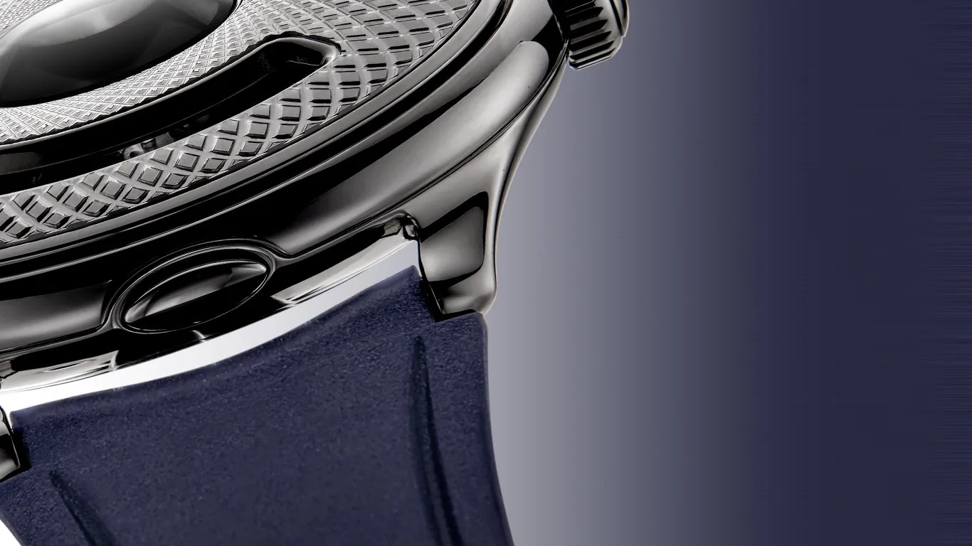 Close-up of a black polished watch case with textured bezel and dark blue strap.