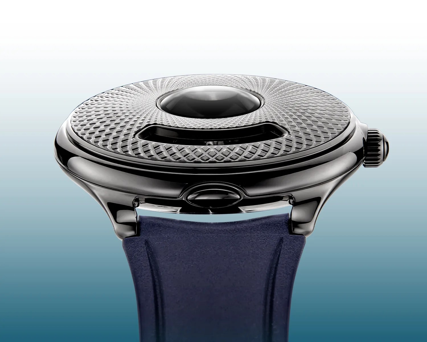Close-up of a watch case with a textured circular top and a dark blue strap.