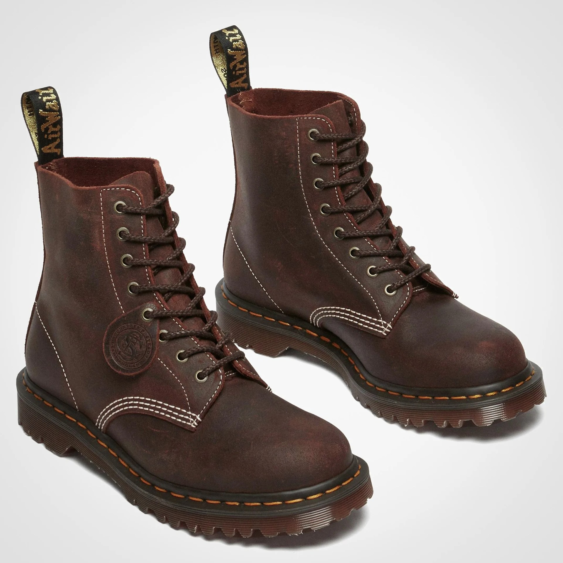 Pair of dark brown leather lace-up boots with thick rubber soles and yellow stitching.