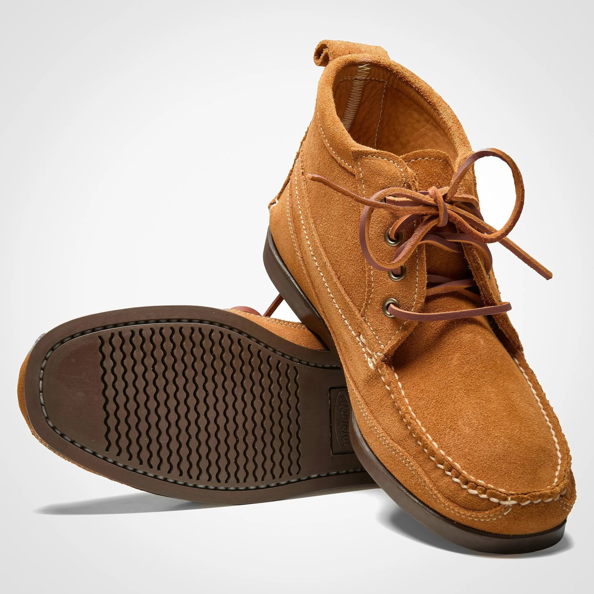 Pair of tan suede moccasin boots with brown rubber soles and leather laces.