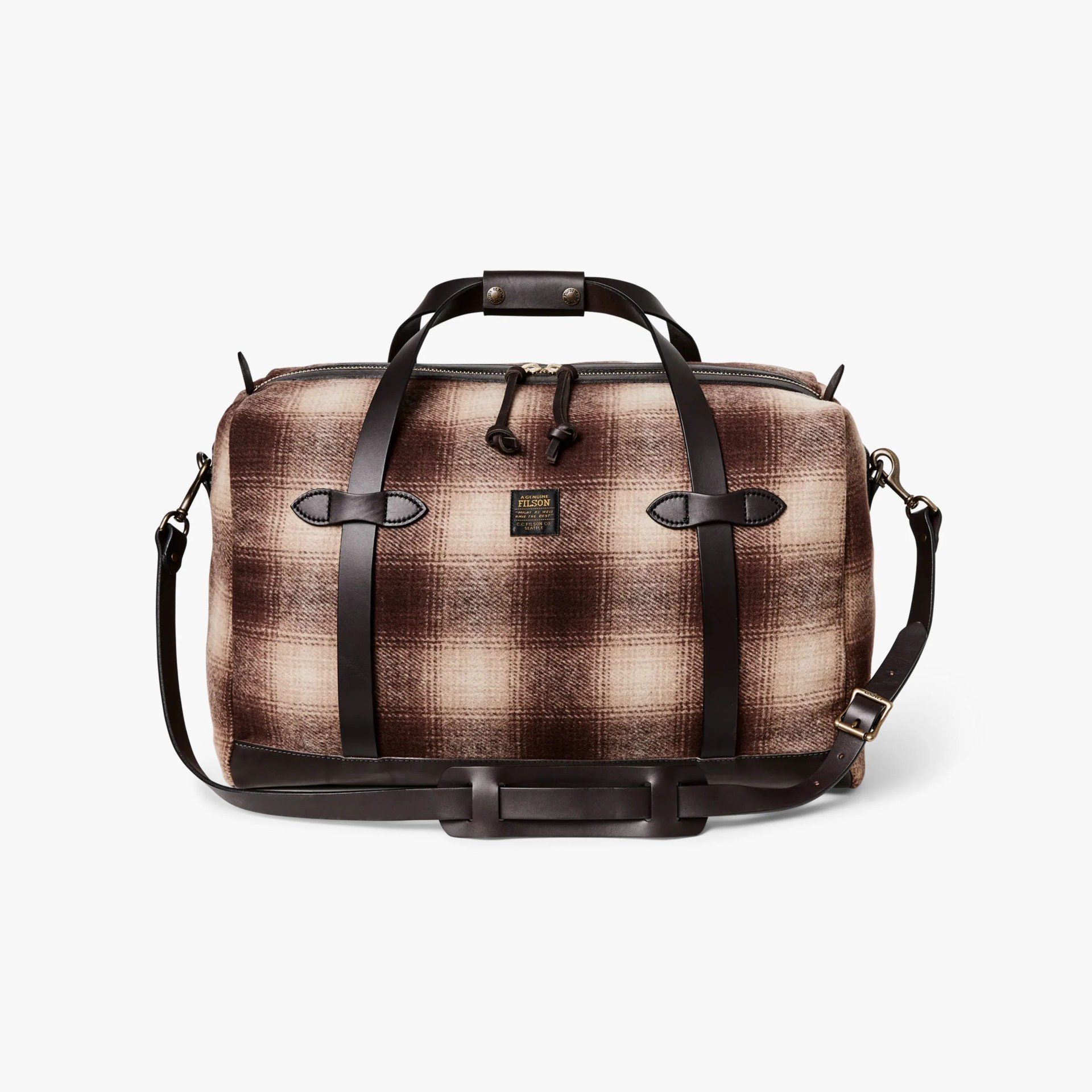 Brown and beige plaid duffel bag with dark brown leather straps and shoulder pad.