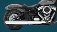 Close-up of the rear half of a gray Harley-Davidson motorcycle showing the seat, exhaust pipes, and engine.