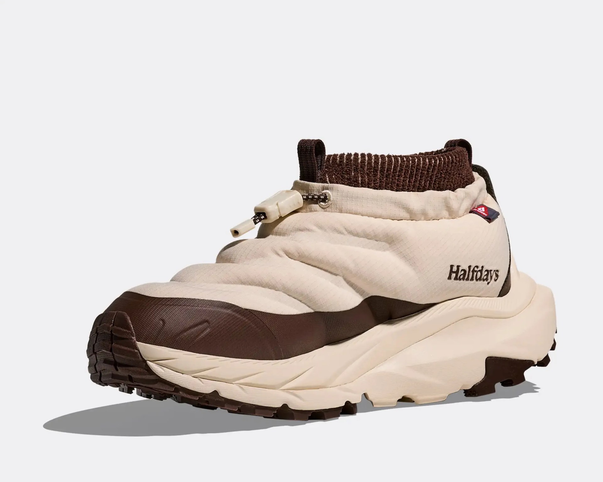 Beige and brown slip-on sneaker with quilted upper, ribbed ankle collar, and "Halfdays" logo on the side.