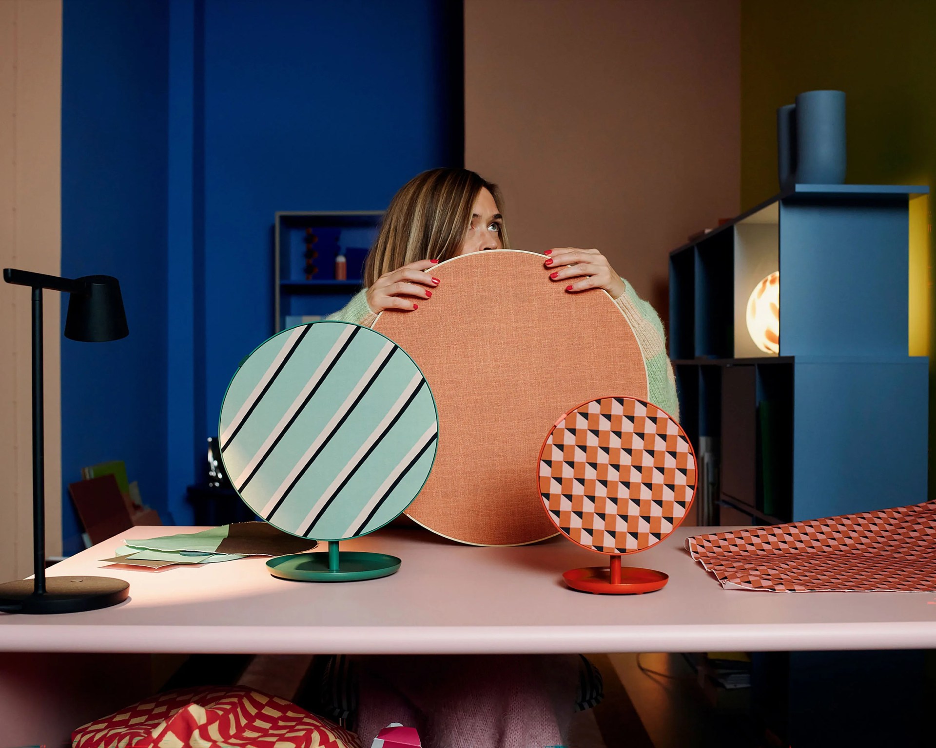 person holding three colorful ikea speakers