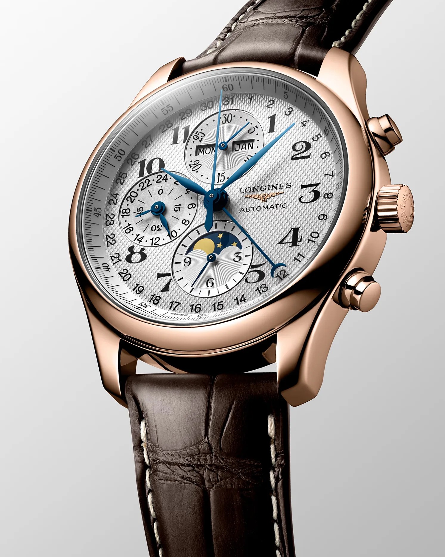 Rose gold Longines automatic wristwatch with white textured dial, blue hands, moon phase, and brown leather strap.