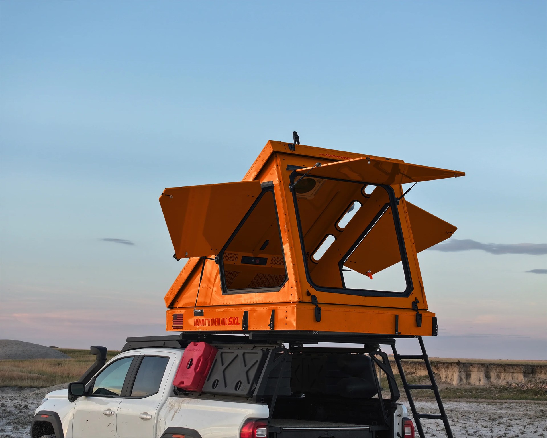 Orange rooftop tent with open windows mounted on a white pickup truck with a ladder and red fuel container.