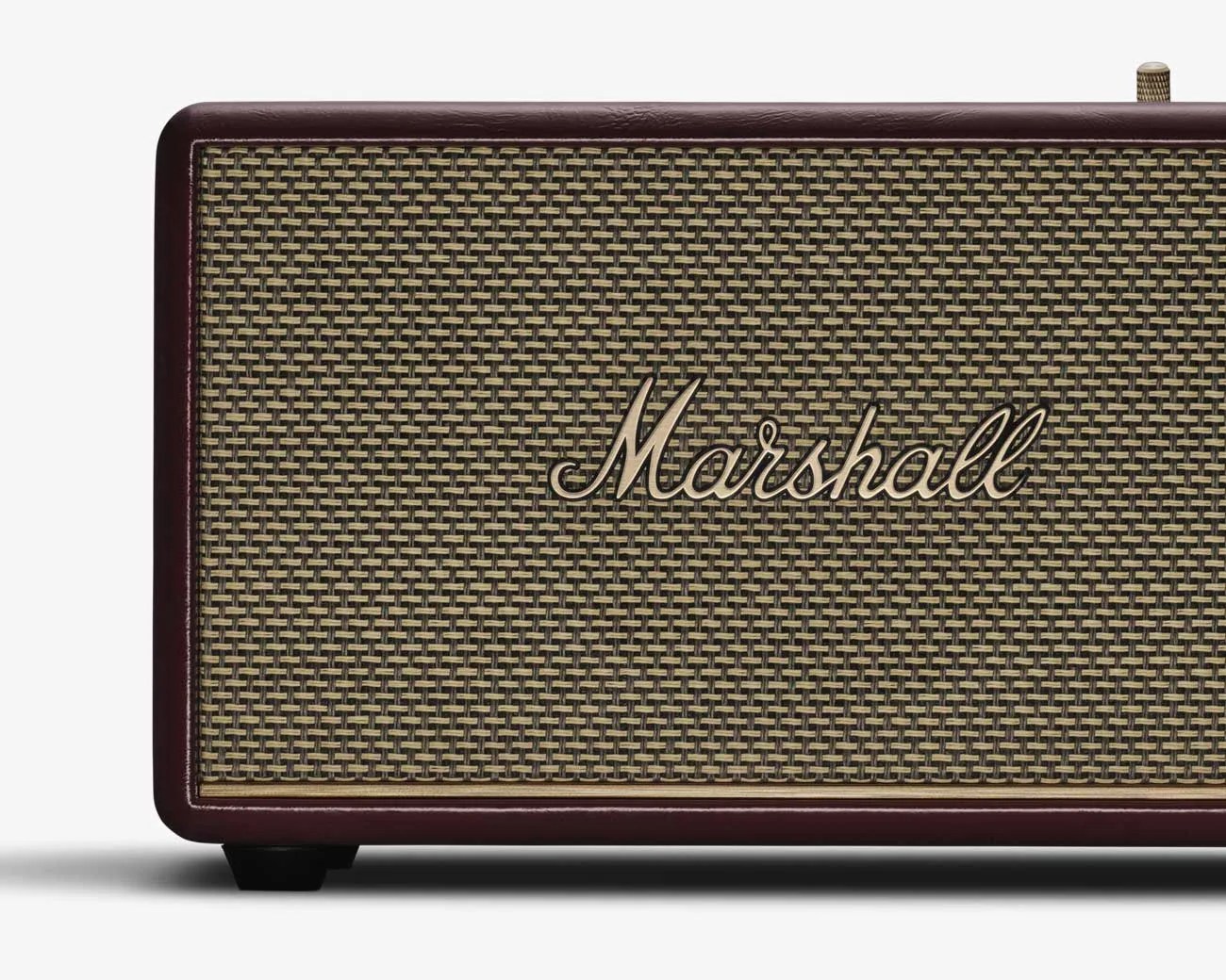 Close-up of a Marshall speaker with woven beige and black grille and dark brown frame.