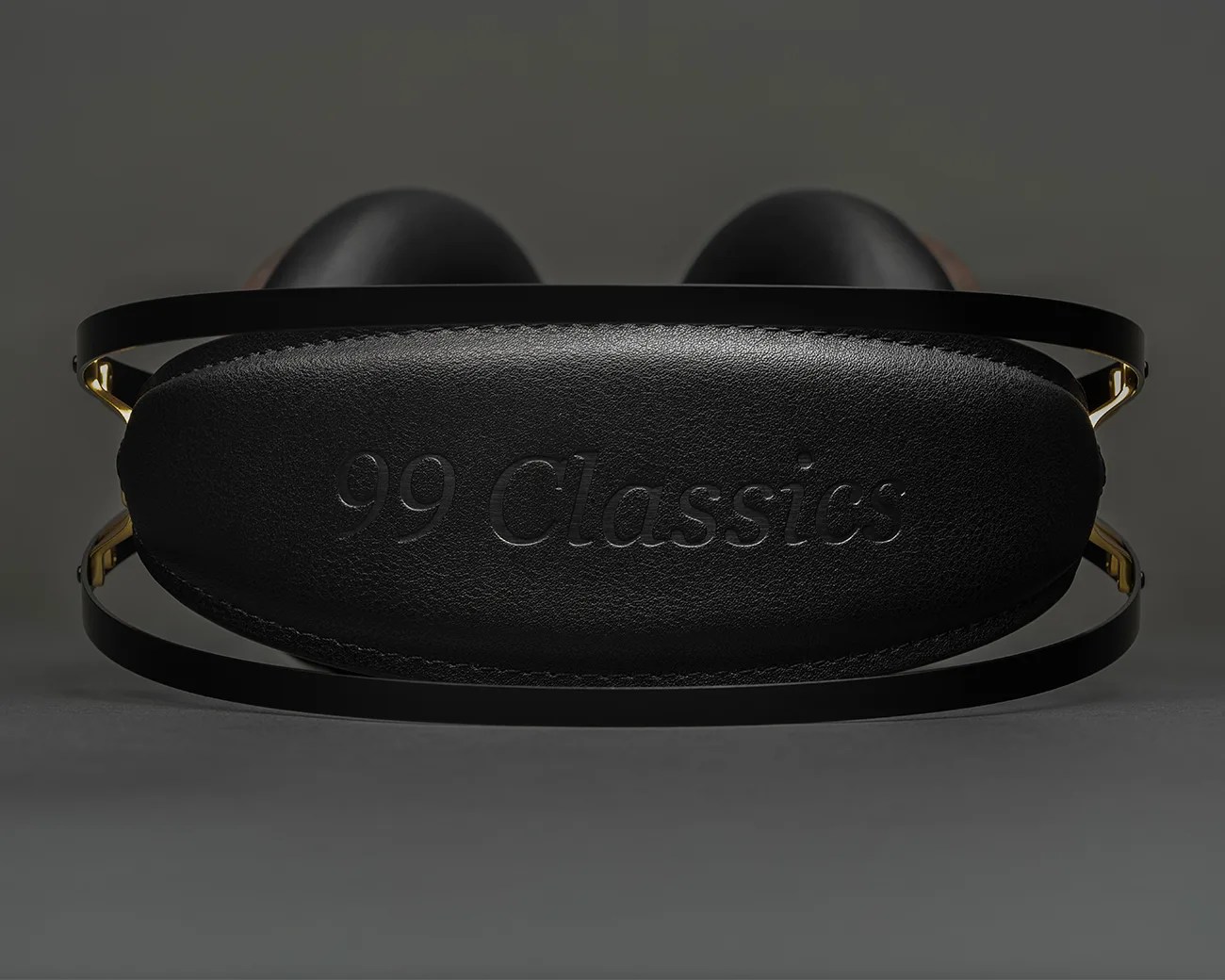 Black leather headphone headband with embossed "99 Classics" text and gold metal frame.