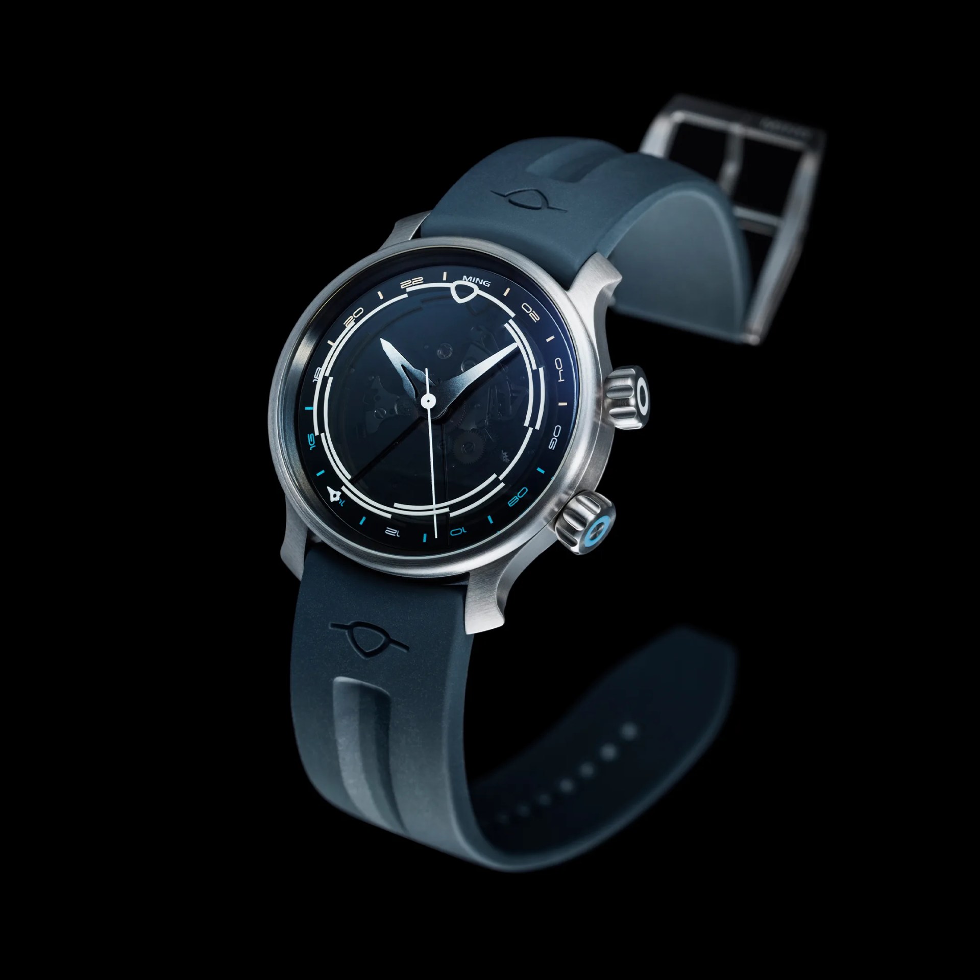 Blue rubber strap watch with silver case and black dial featuring white and blue markings.
