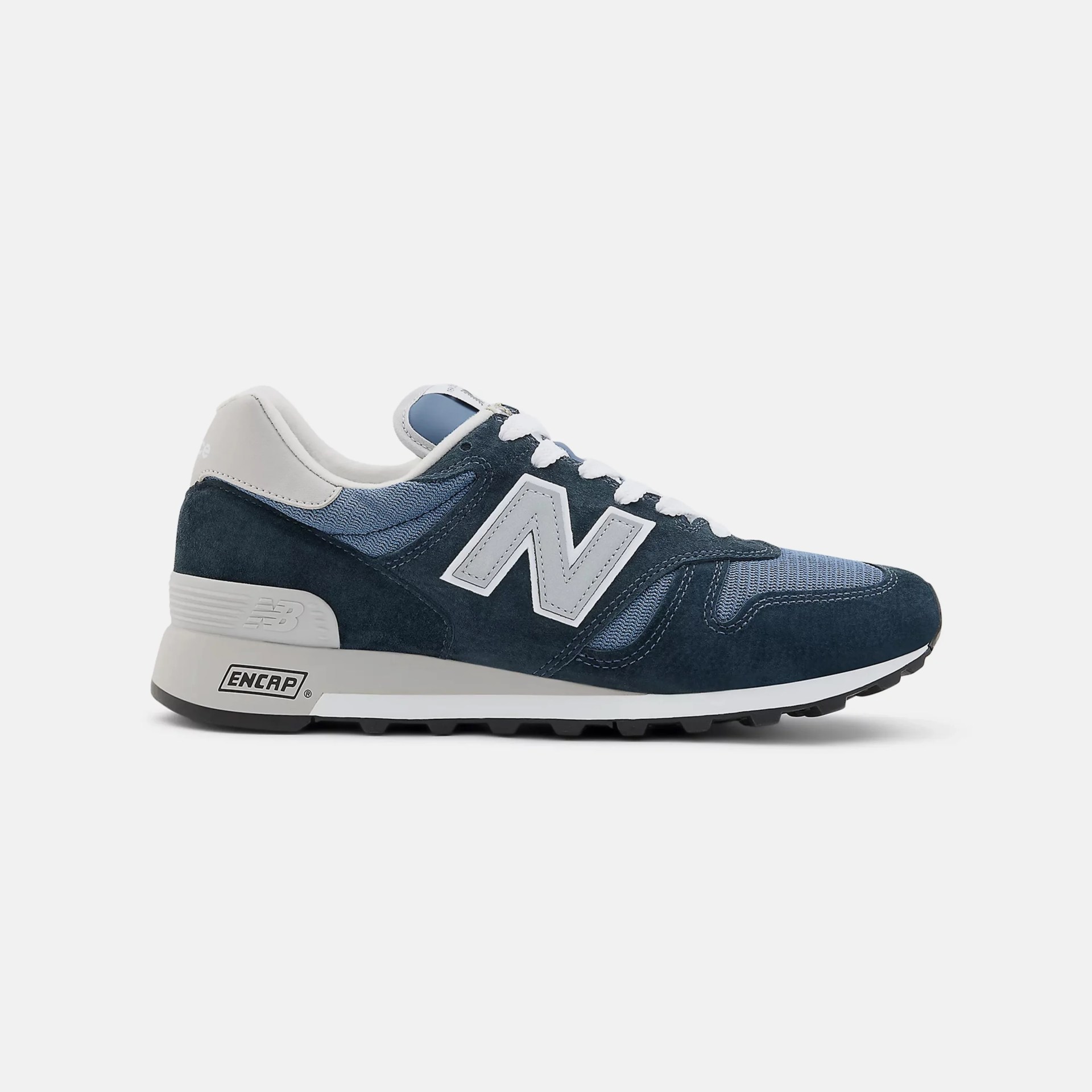 Navy blue and light gray New Balance sneaker with suede and mesh upper and white laces.