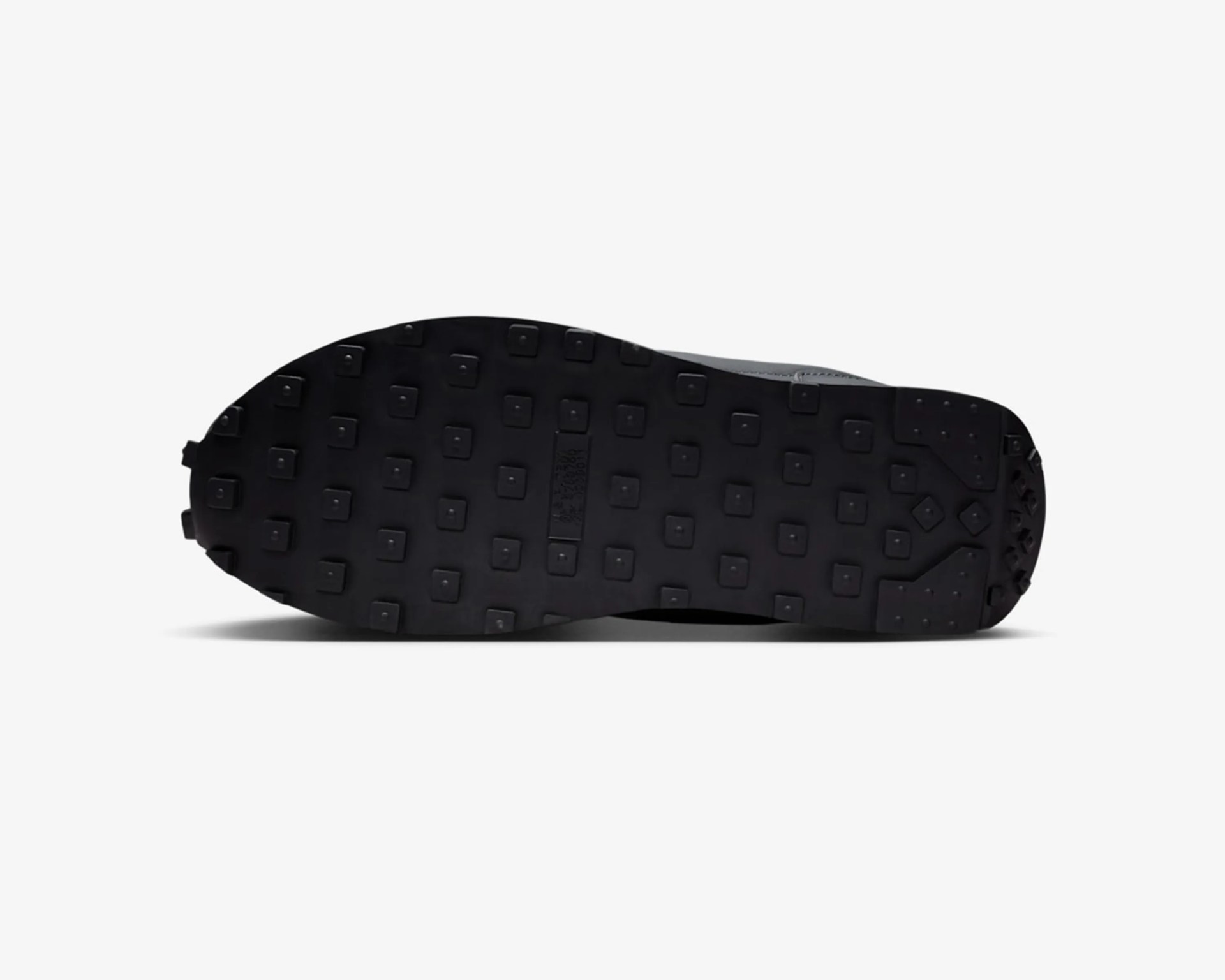 Black rubber shoe sole with square tread pattern and small raised studs.