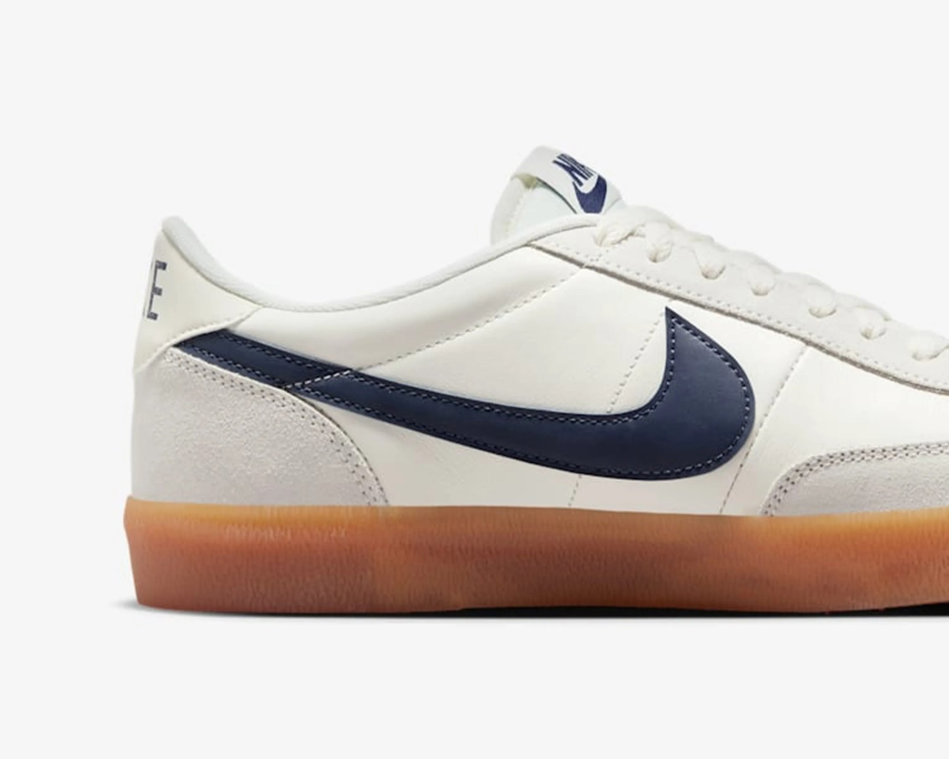 White leather Nike sneaker with navy blue swoosh and gum rubber sole.