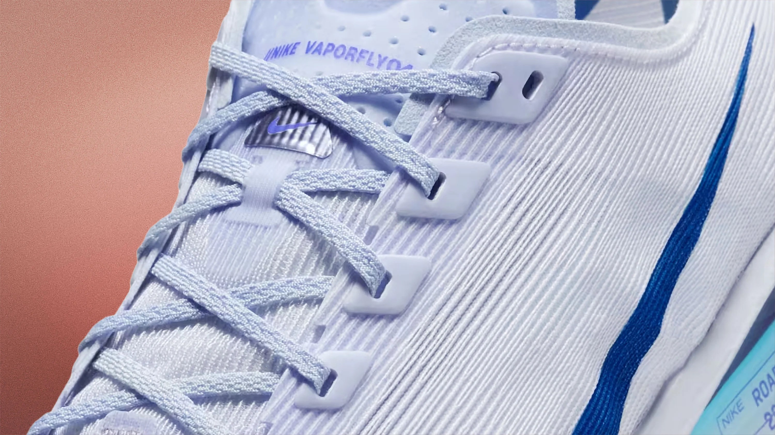 Close-up of a light blue Nike Vaporfly running shoe with textured fabric and blue swoosh logo.