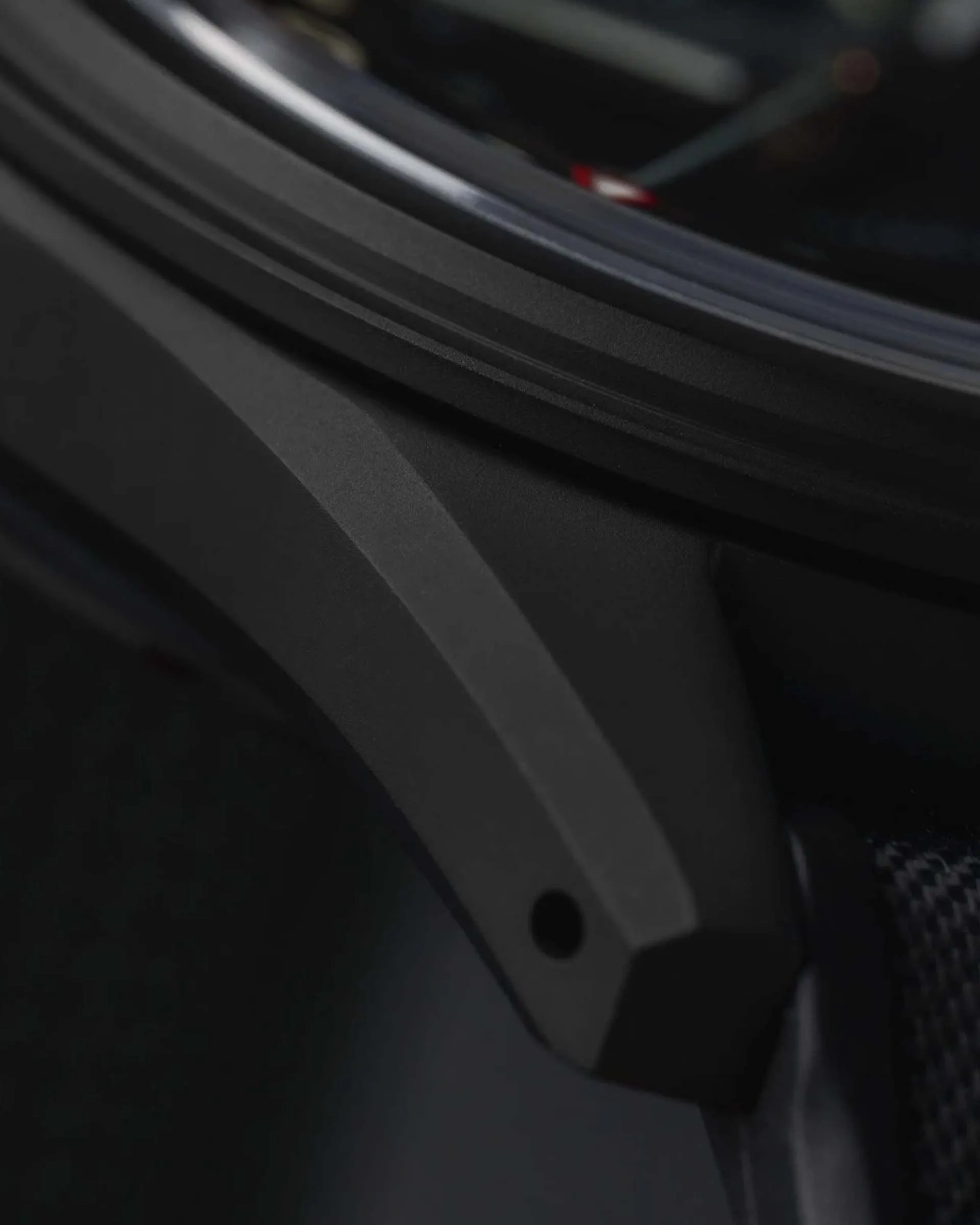 Close-up of a matte black watch case lug with a small hole near the edge.