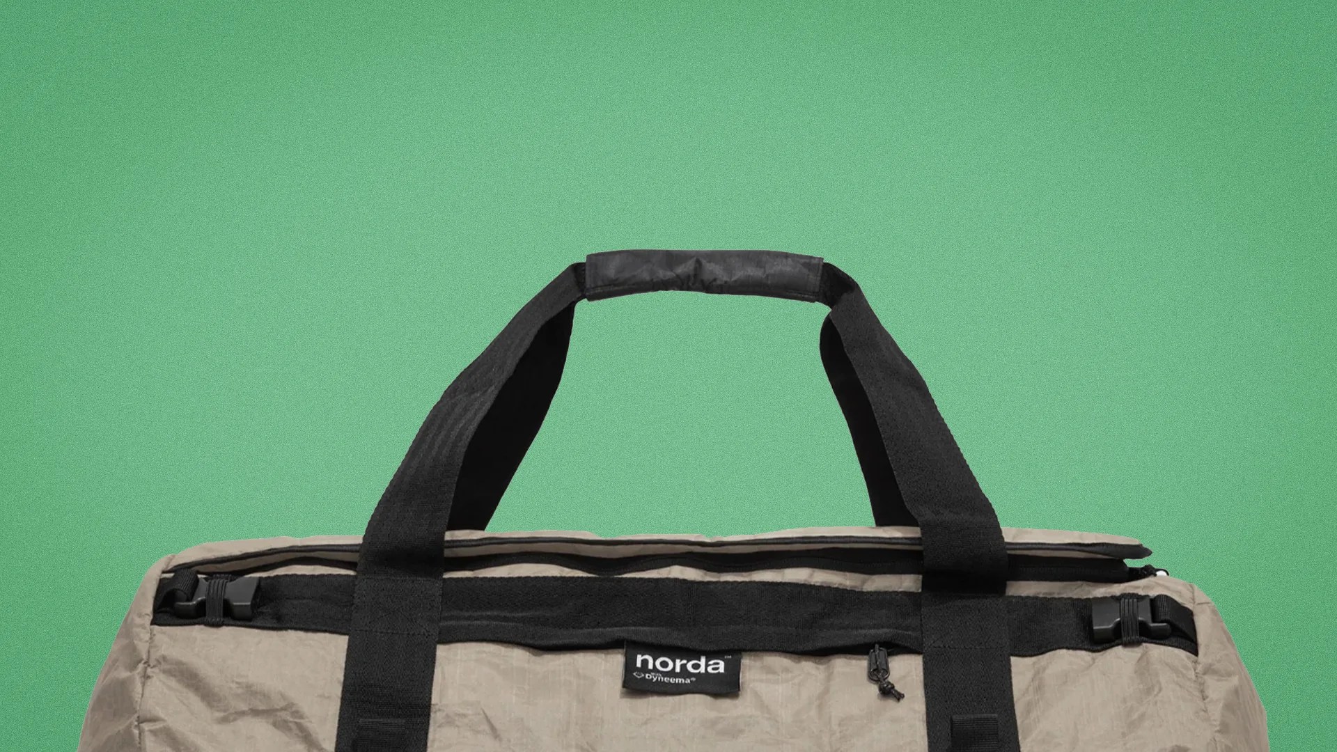 Beige duffel bag with black handles and zipper, featuring a "norda by Dyneema" label.
