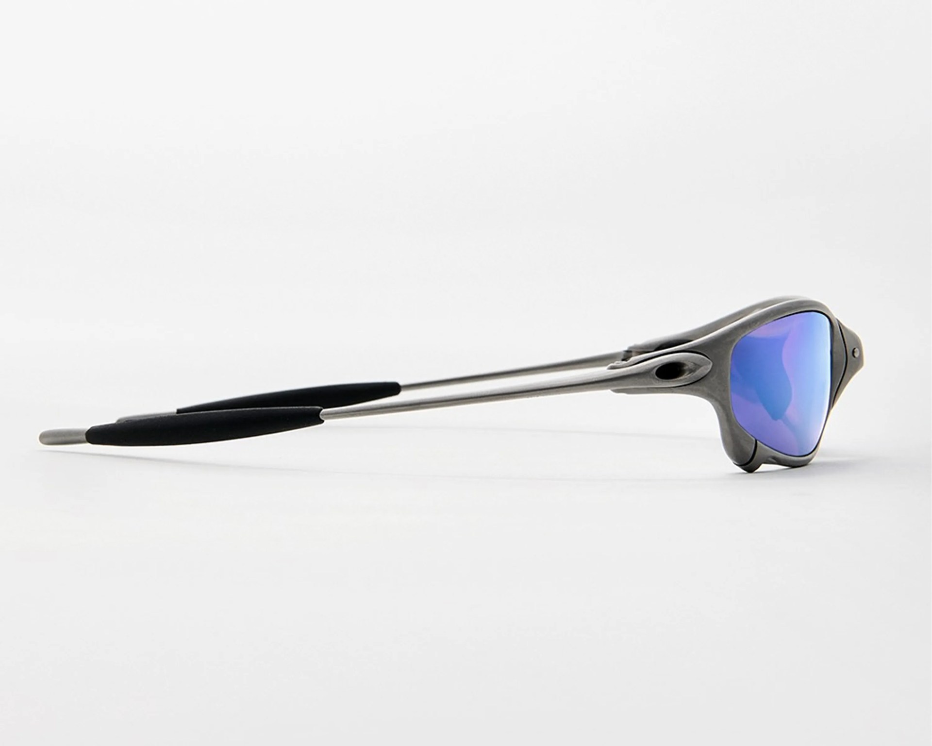 Sporty sunglasses with metallic frame and blue mirrored lenses lying on a white surface.