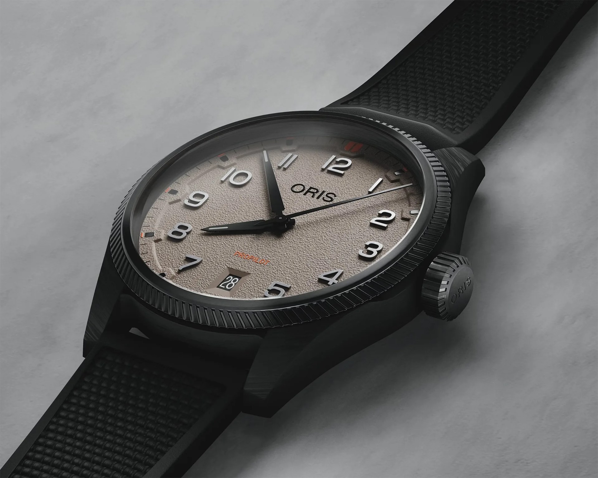 Black Oris ProPilot wristwatch with textured beige dial, silver numerals, black rubber strap, and date display at 6 o'clock.