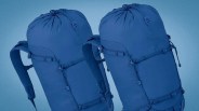 Two blue hiking backpacks with padded shoulder straps and compression straps on a blue gradient background.