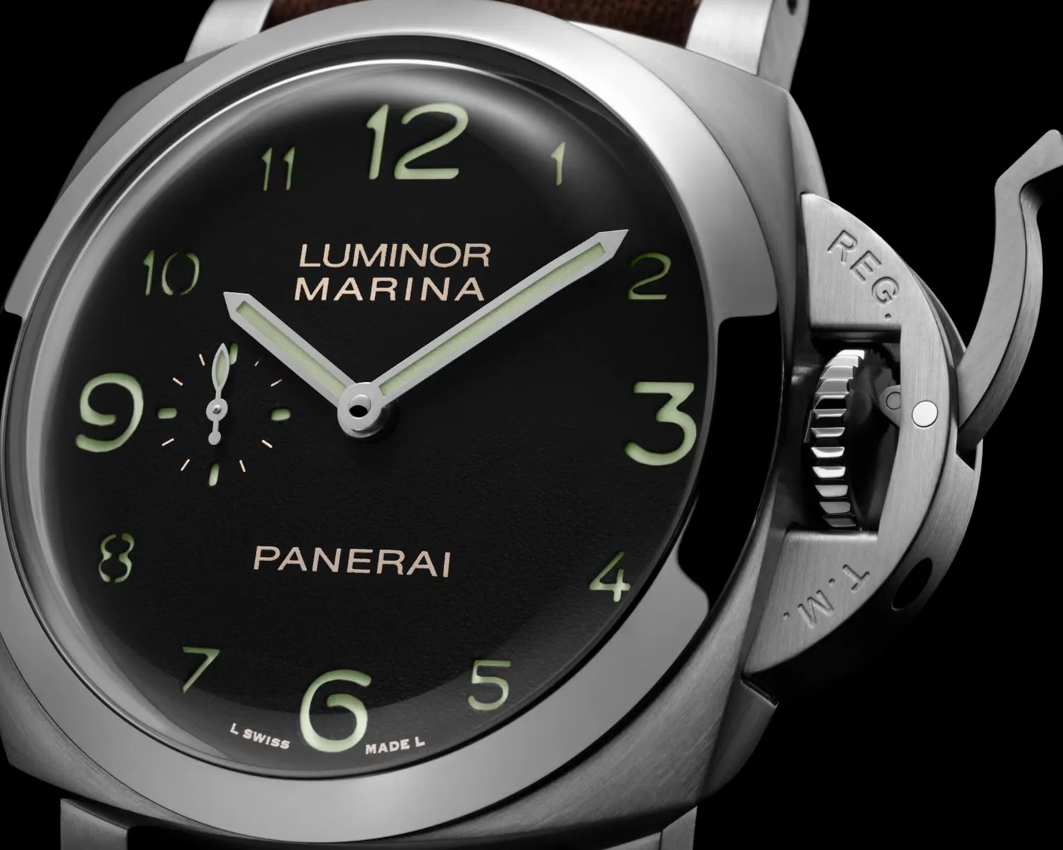 Close-up of a Panerai Luminor Marina watch with a black dial, luminous green numerals, and a brushed stainless steel case.