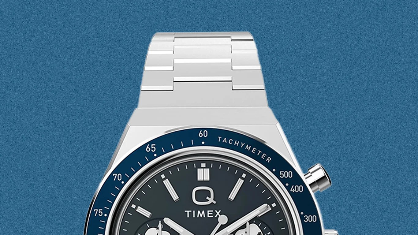 Silver metal wristwatch with a dark blue tachymeter bezel and black dial featuring three subdials and silver markers.