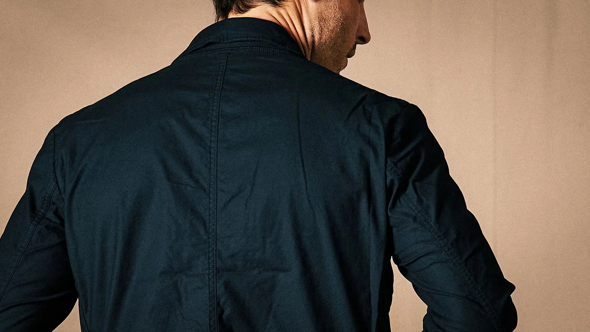 Dark navy jacket with visible seam details worn by a person facing away.