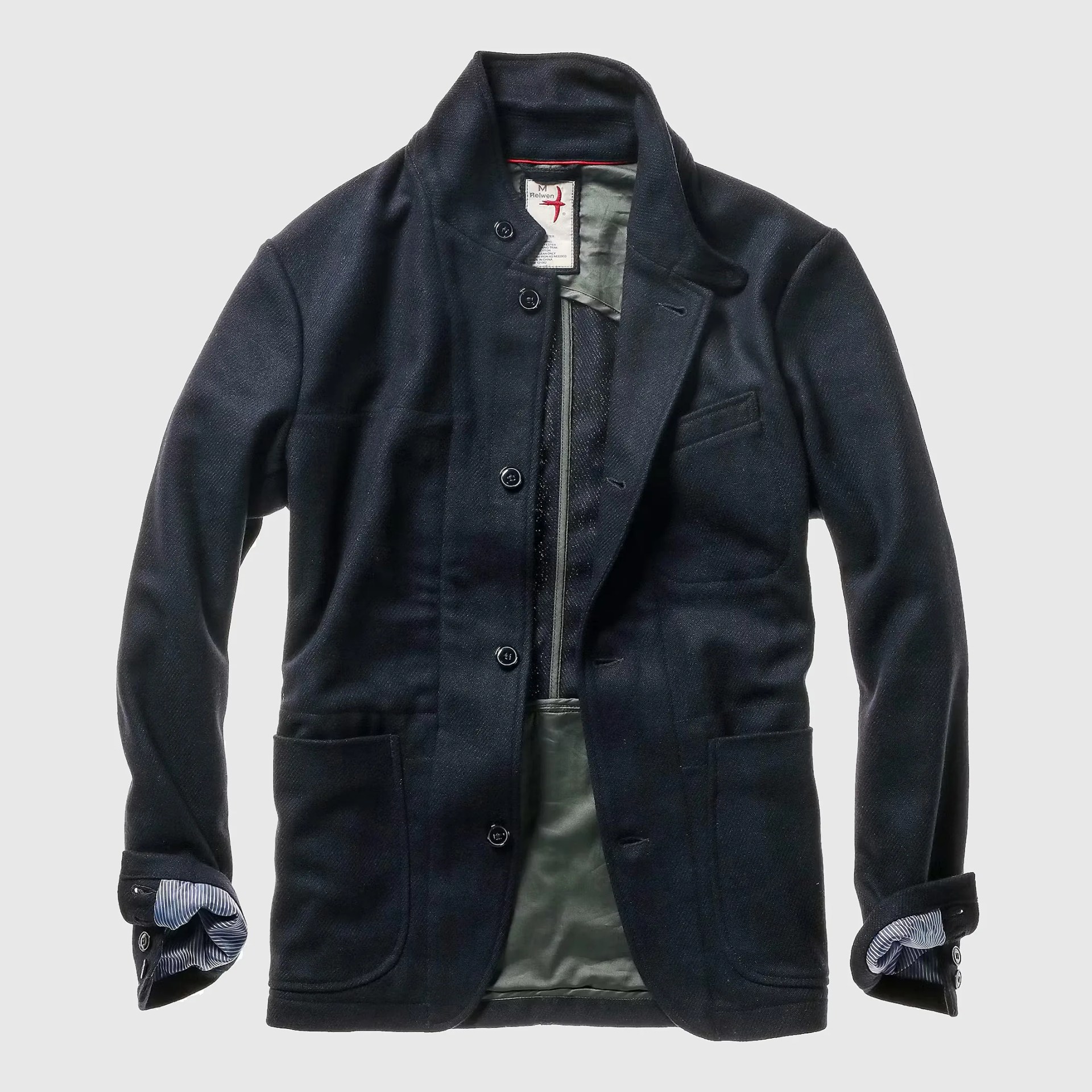 Black wool blazer with button closure and striped shirt cuffs showing.