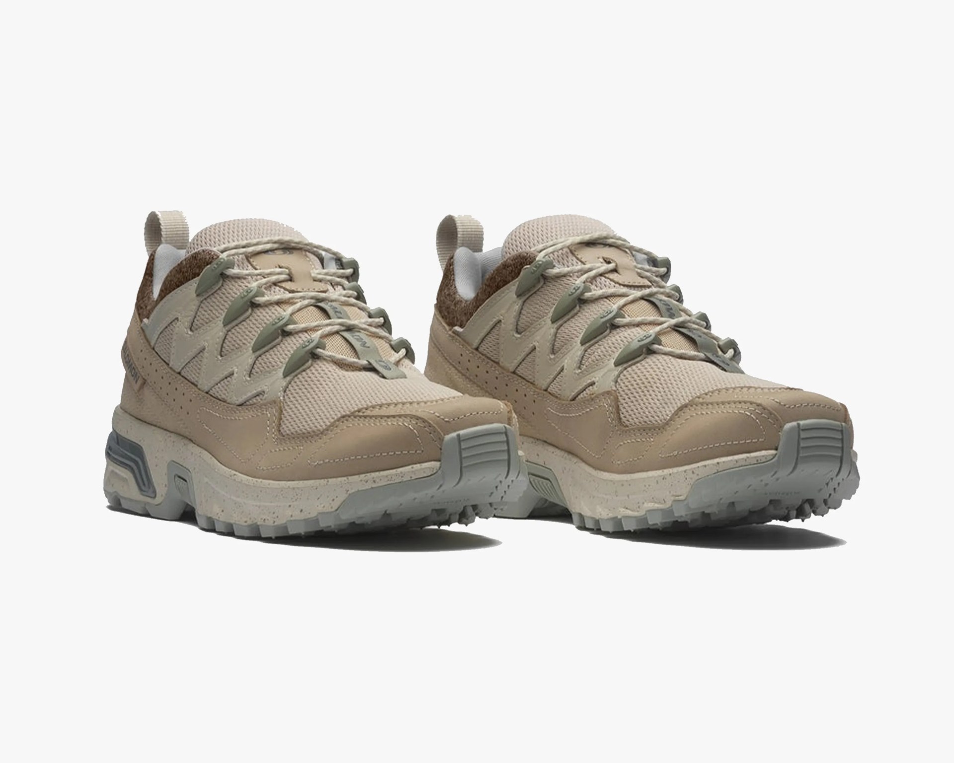 Pair of beige and tan hiking shoes with mesh and suede upper and thick speckled sole.