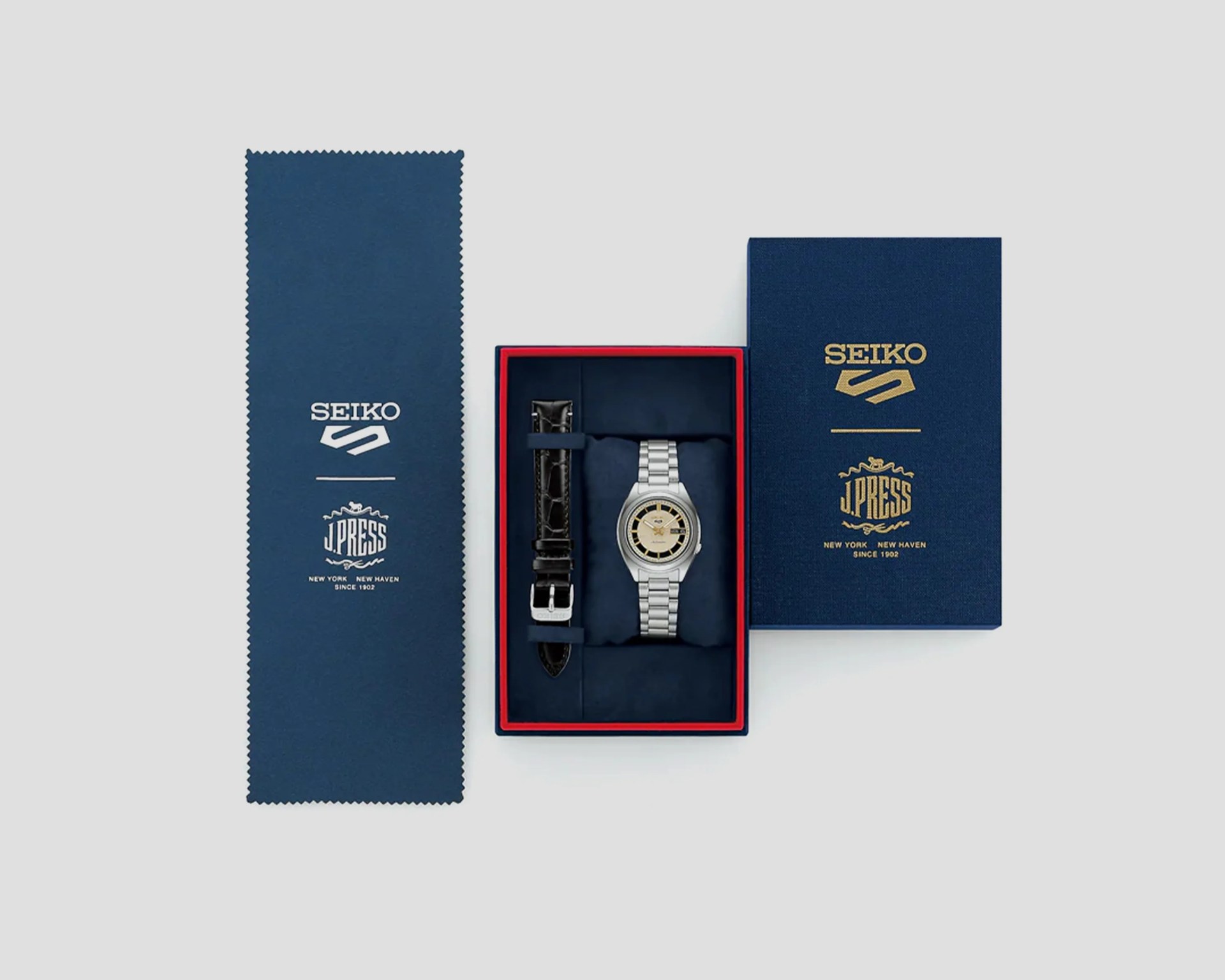 Silver Seiko wristwatch with beige and black dial and metal bracelet, extra black leather strap, in blue Seiko and J.Press branded box.
