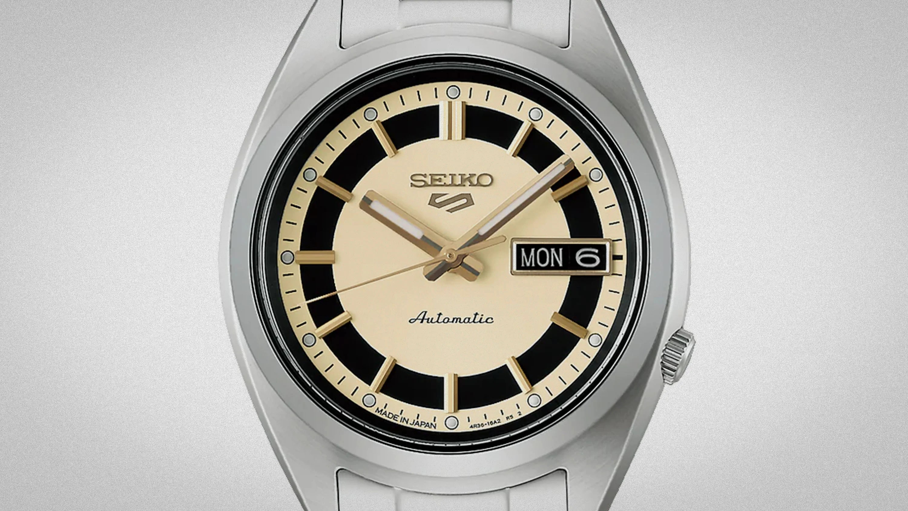 Silver Seiko automatic wristwatch with cream and black dial and day-date display showing Monday the 6th.