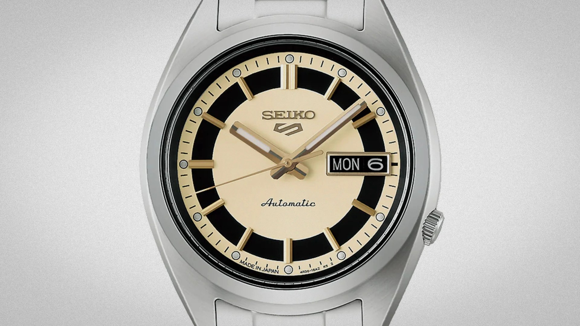 Silver Seiko automatic wristwatch with cream and black dial and day-date display showing Monday the 6th.