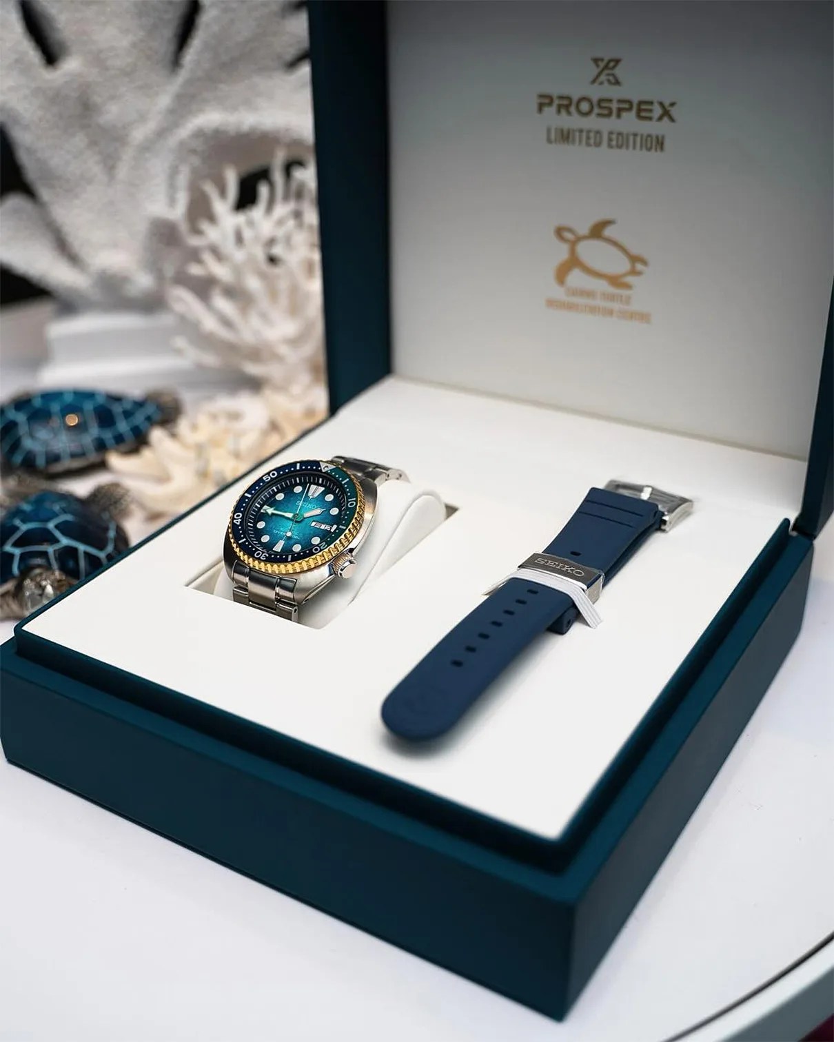 Blue dial Seiko Prospex limited edition watch with gold bezel and metal bracelet in a presentation box with an extra blue strap.
