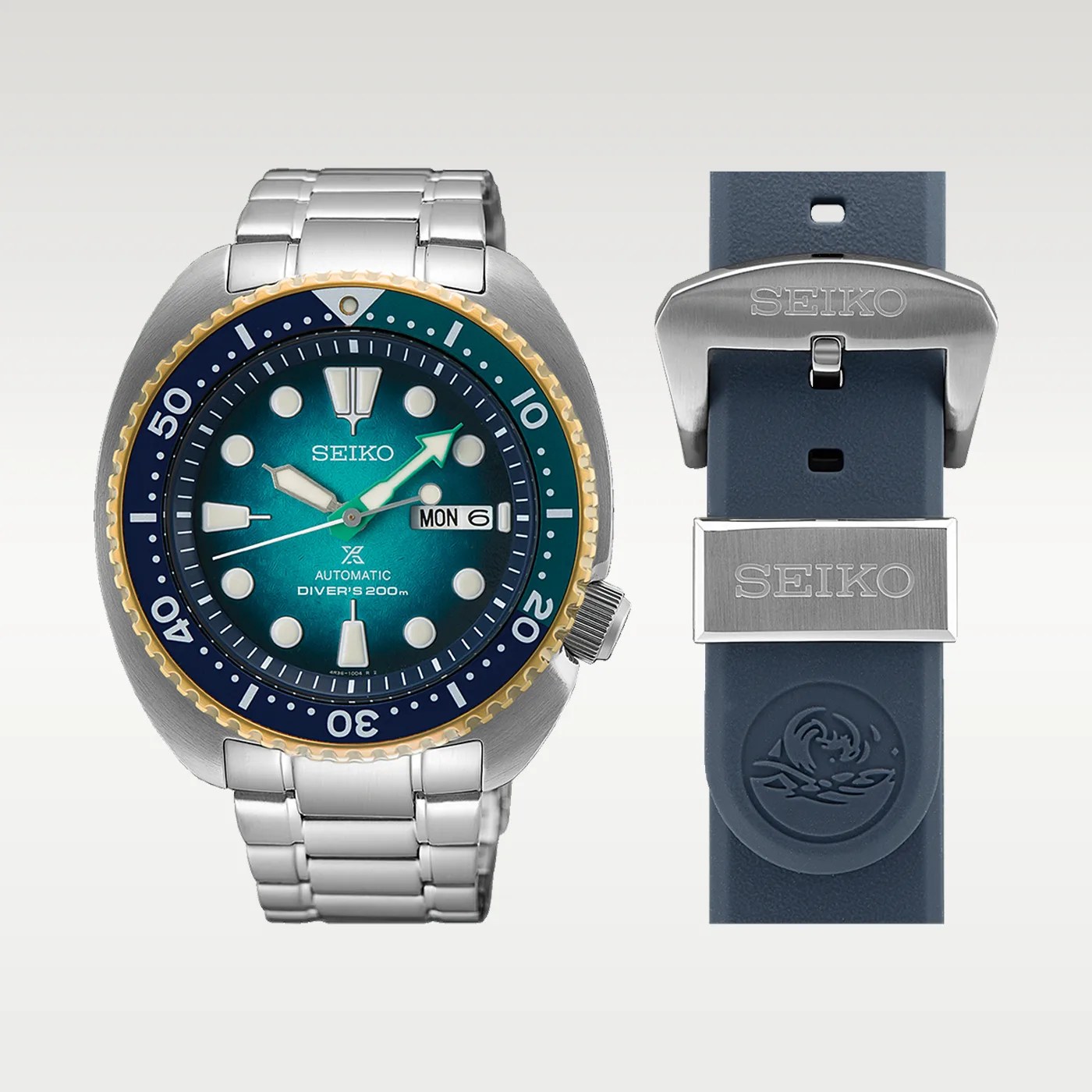 Seiko automatic diver's watch with blue-green dial, gold and blue bezel, stainless steel bracelet, and blue rubber strap with Seiko buckle.