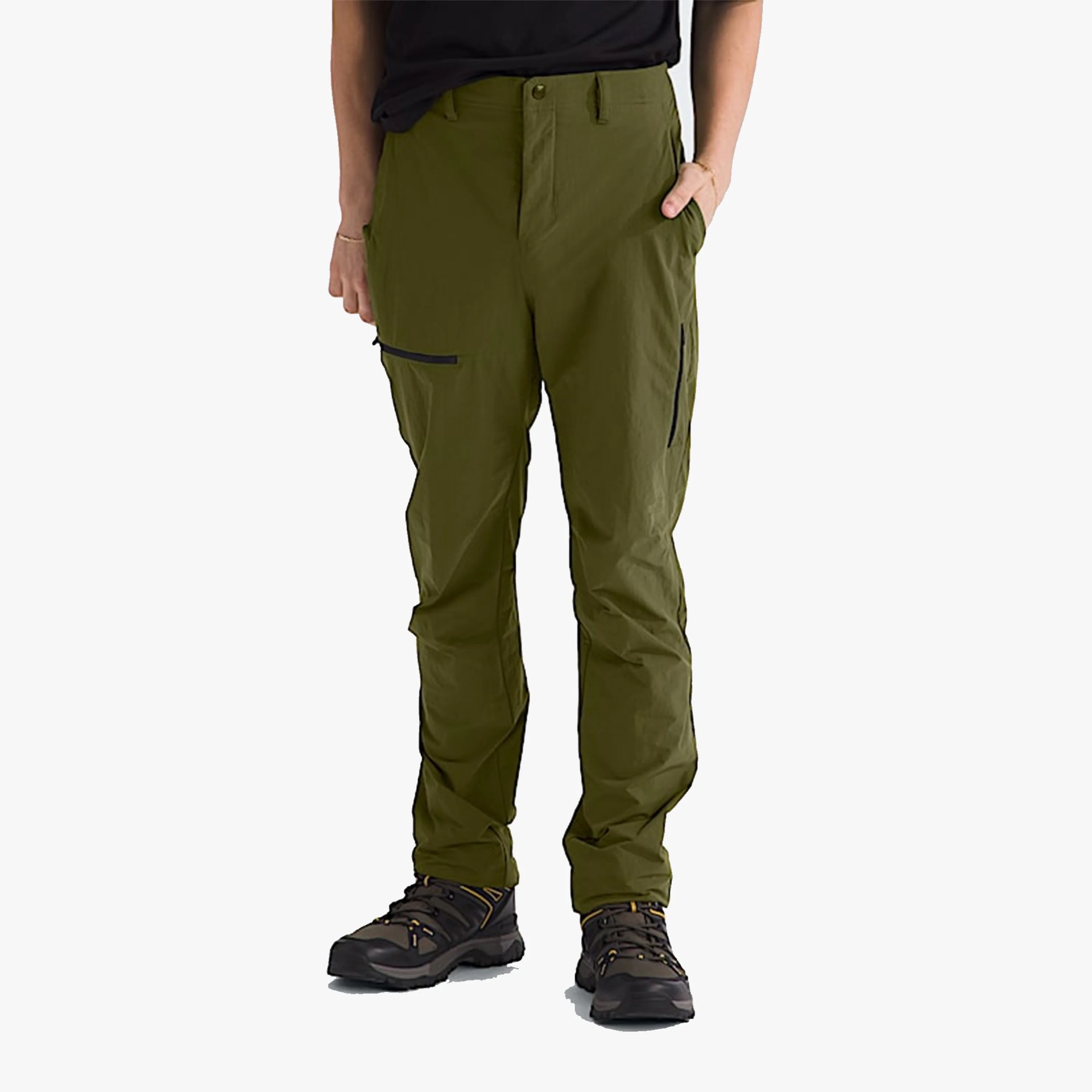 Olive green outdoor pants with zippered thigh pockets worn with black hiking shoes.