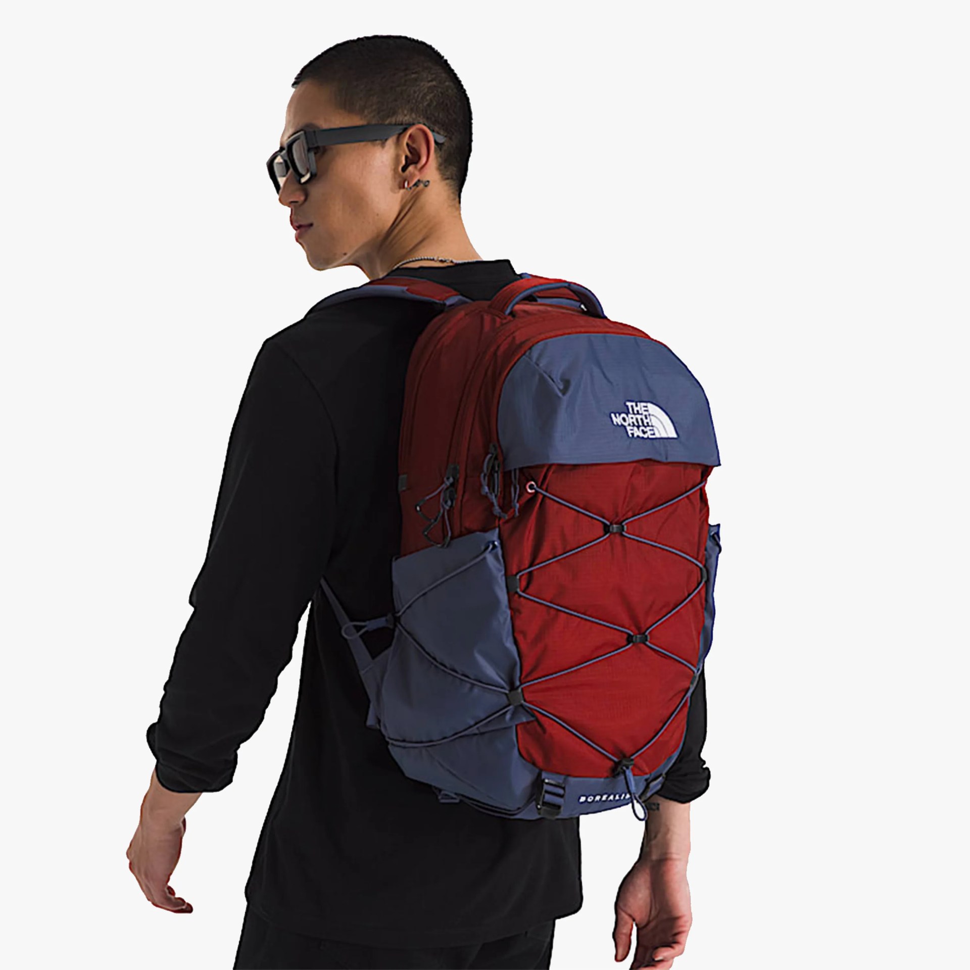 Red and blue The North Face Borealis backpack worn by a person in a black long-sleeve shirt.