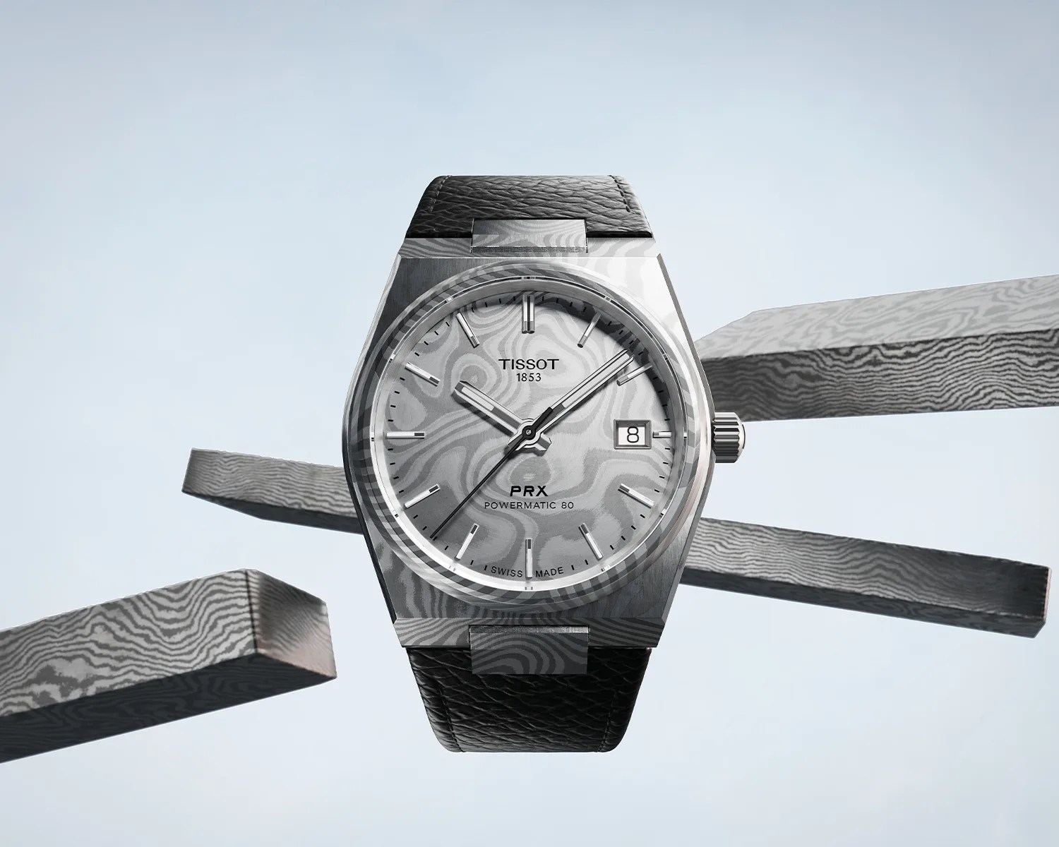 Silver Tissot PRX Powermatic 80 watch with a black leather strap and a date window at 3 o'clock.
