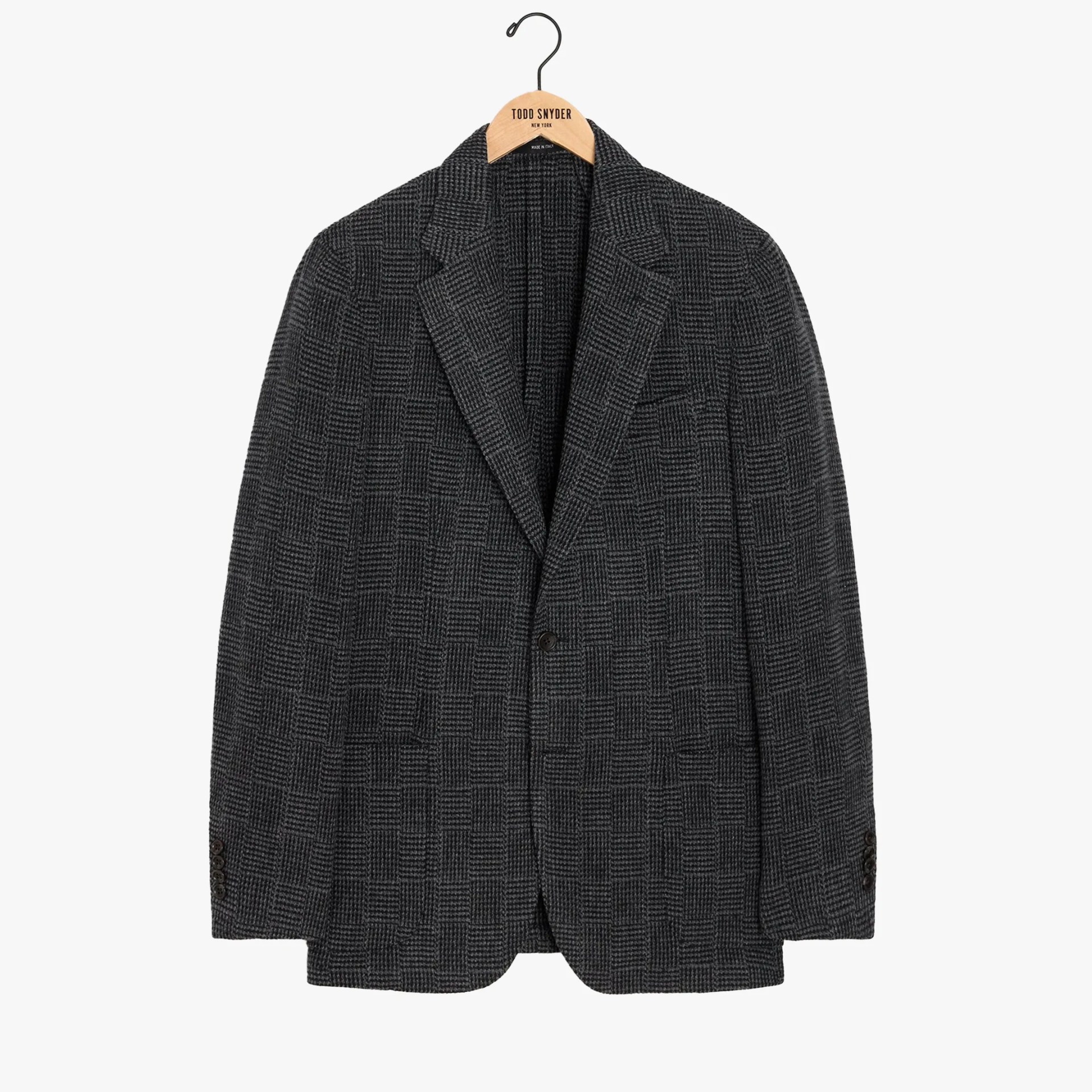 Dark gray checkered blazer with notch lapels and single-button closure on a wooden hanger.