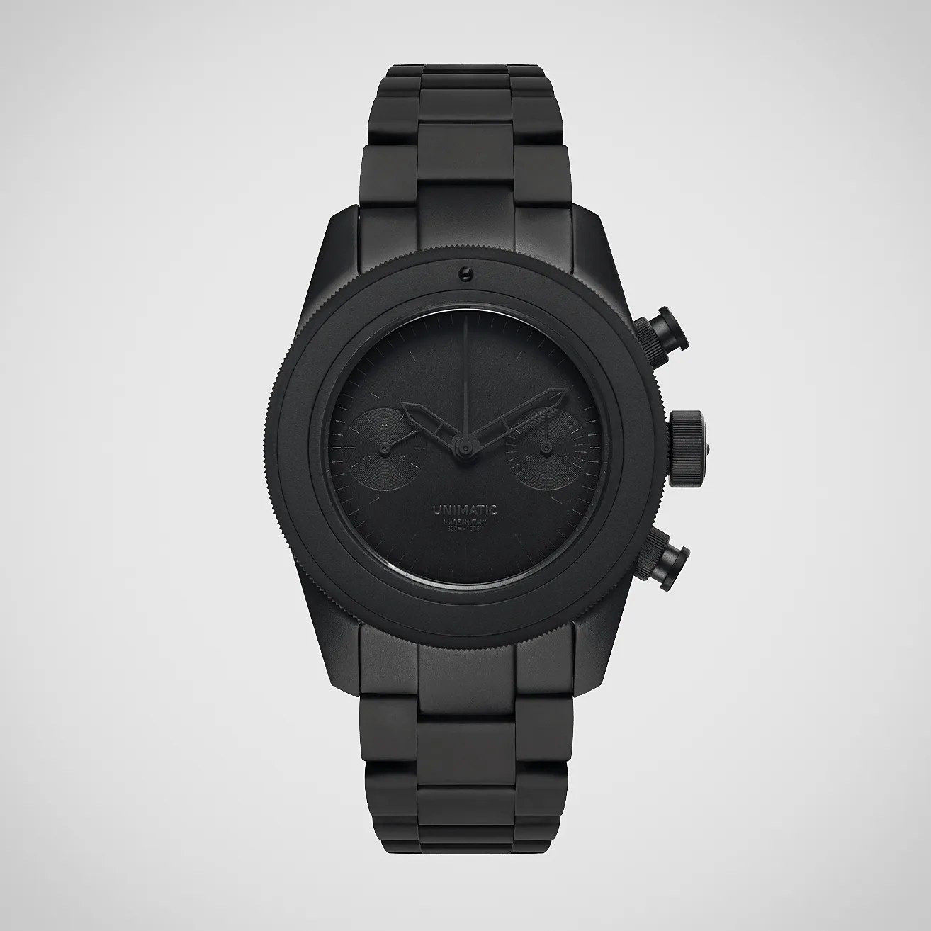 Matte black Unimatic wristwatch with metal link bracelet and chronograph buttons on the side.