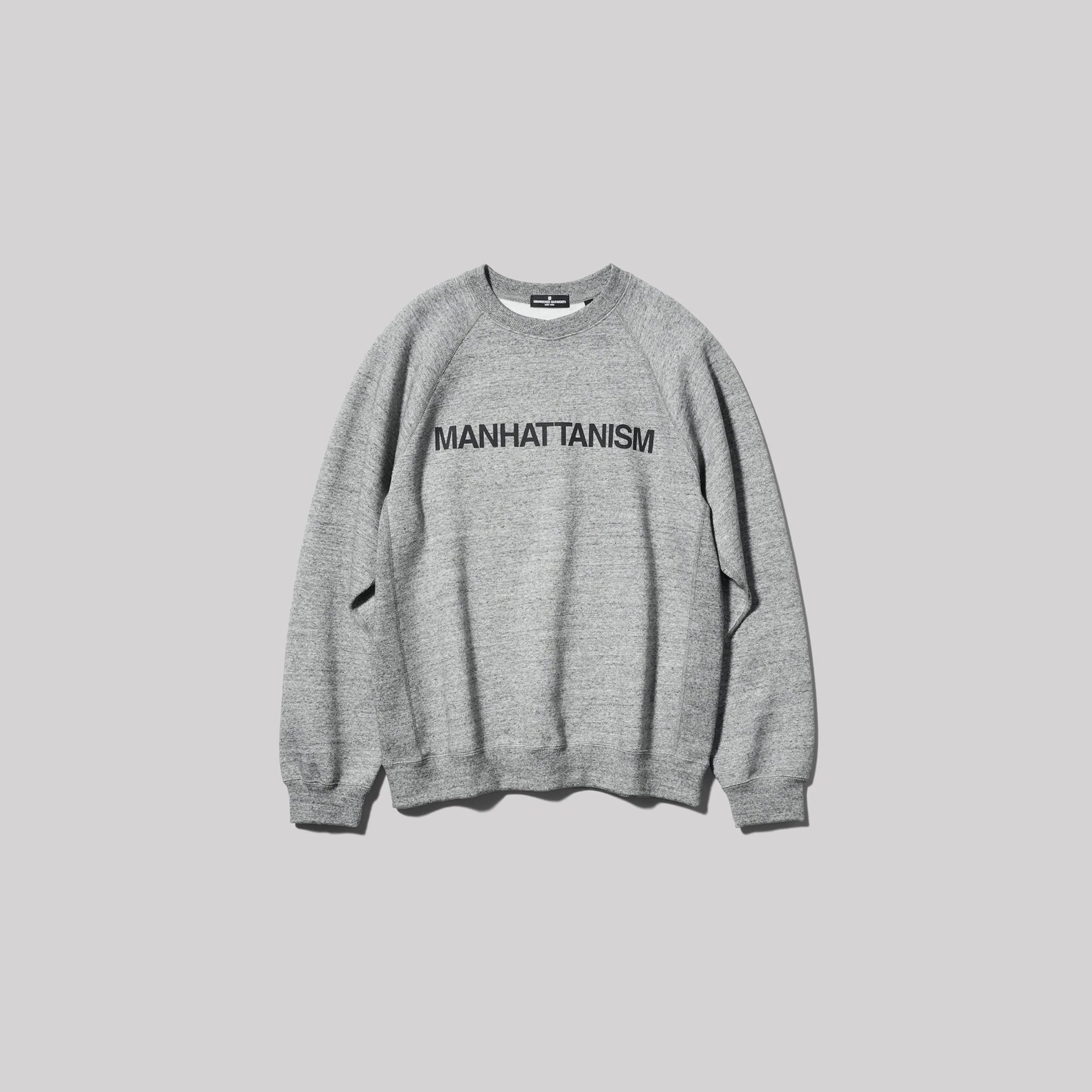 Gray crewneck sweatshirt with "MANHATTANISM" printed in black across the chest.