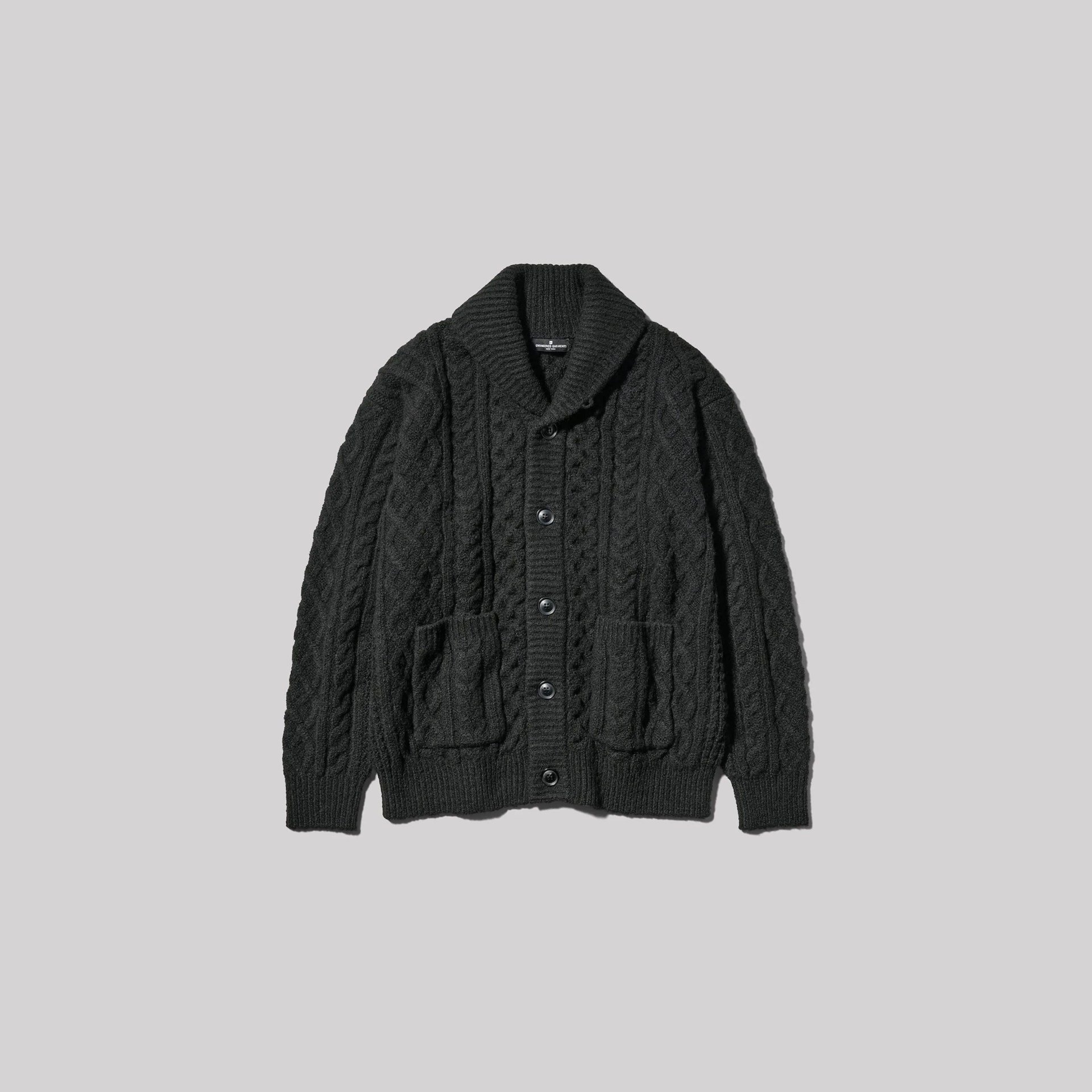 Dark gray cable-knit cardigan with shawl collar and front pockets laid flat on a light gray background.