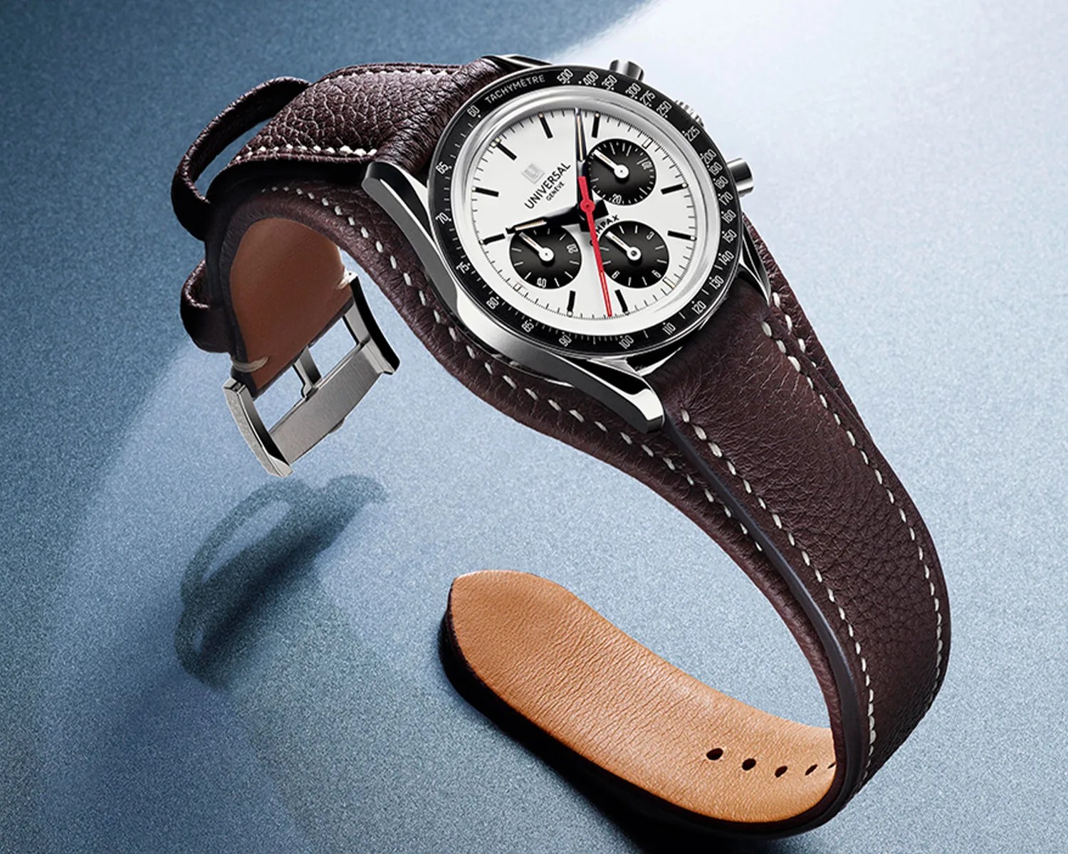 Silver chronograph watch with white dial, black subdials, red second hand, and brown leather strap with white stitching.