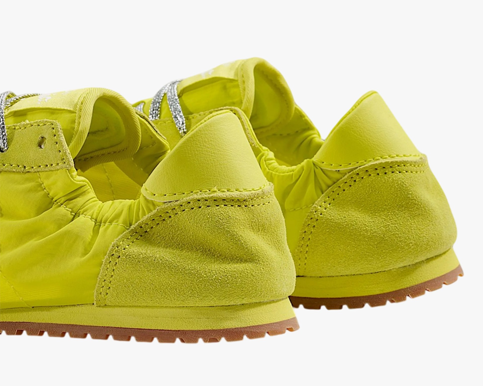 Pair of bright yellow sneakers with suede and leather heel accents and brown rubber soles.