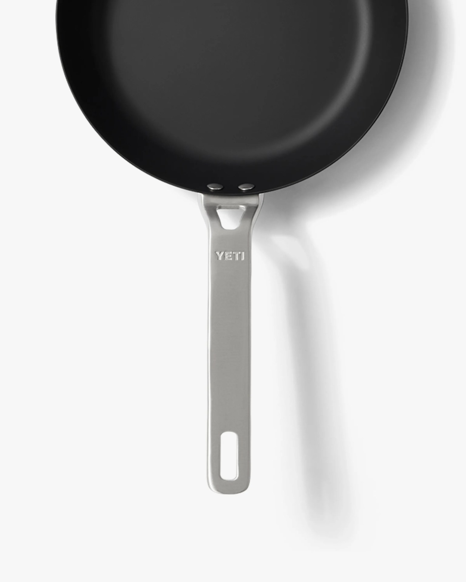 Black nonstick frying pan with a silver metal handle embossed with "YETI" on a white background.