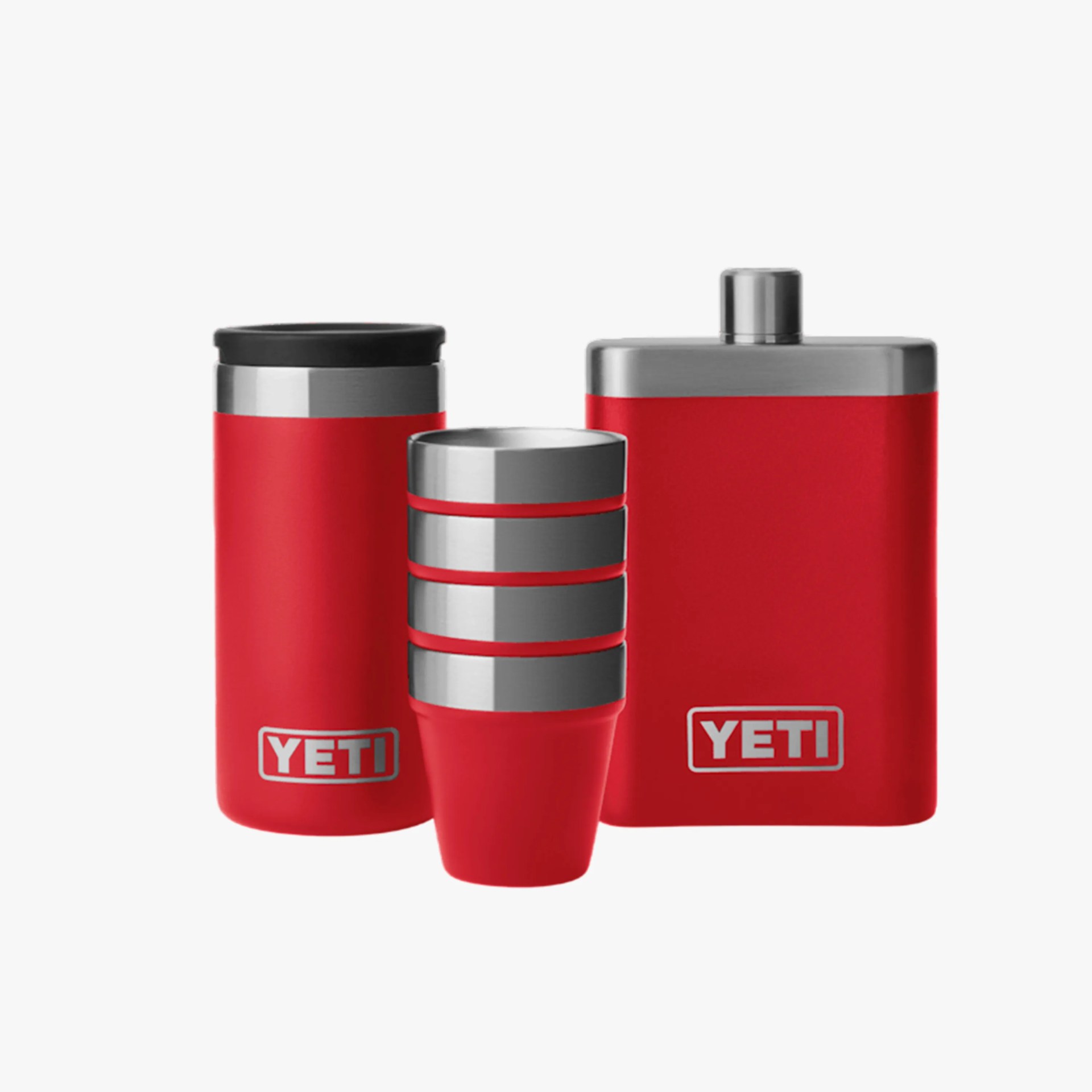 Set of red YETI stainless steel drinkware including a tumbler, three stacked cups, and a flask.