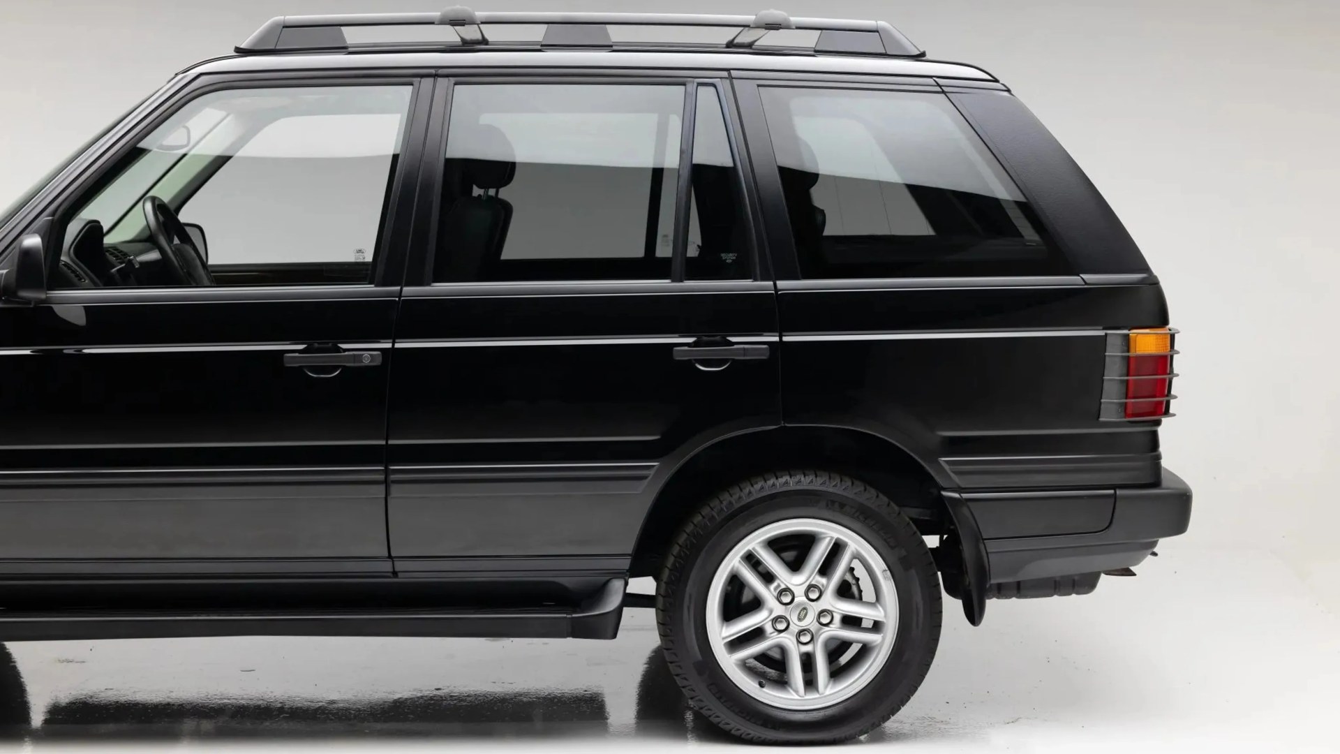 Black SUV with silver alloy wheels and roof rails shown from the side on a white background.