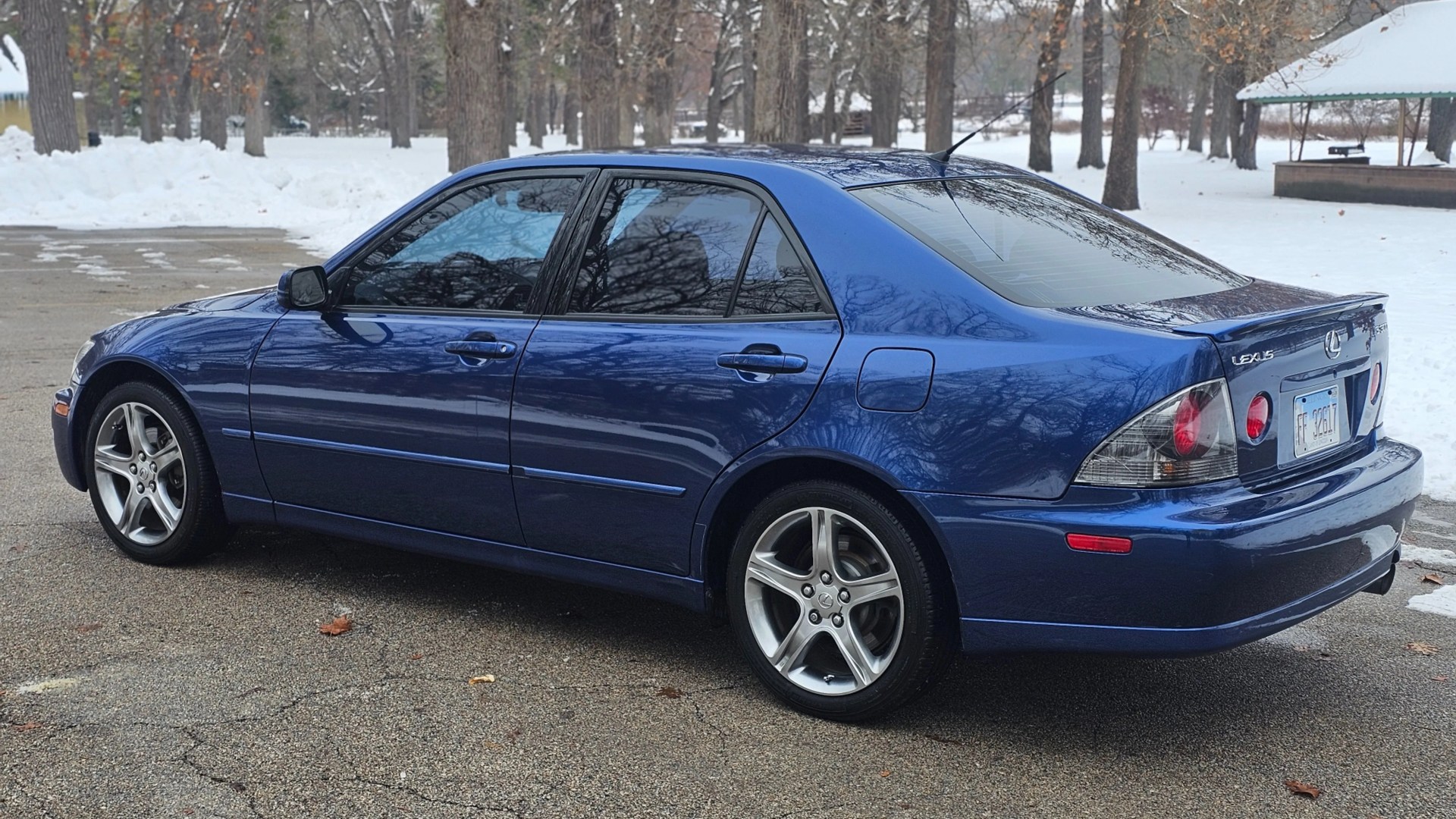 Blue Lexus sedan parked on a snowy road with alloy wheels and tinted windows.