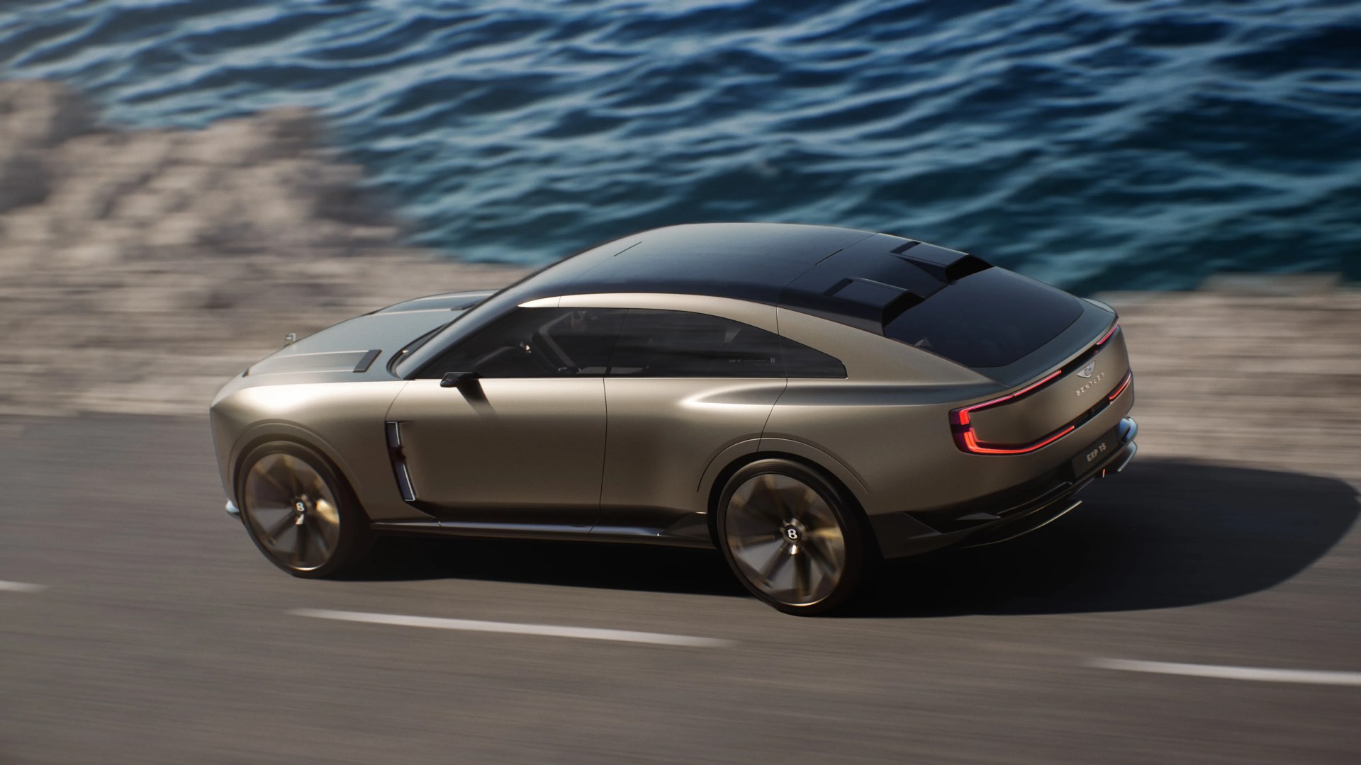 Metallic gold luxury coupe with black roof and distinctive rear LED lights driving on a coastal road.